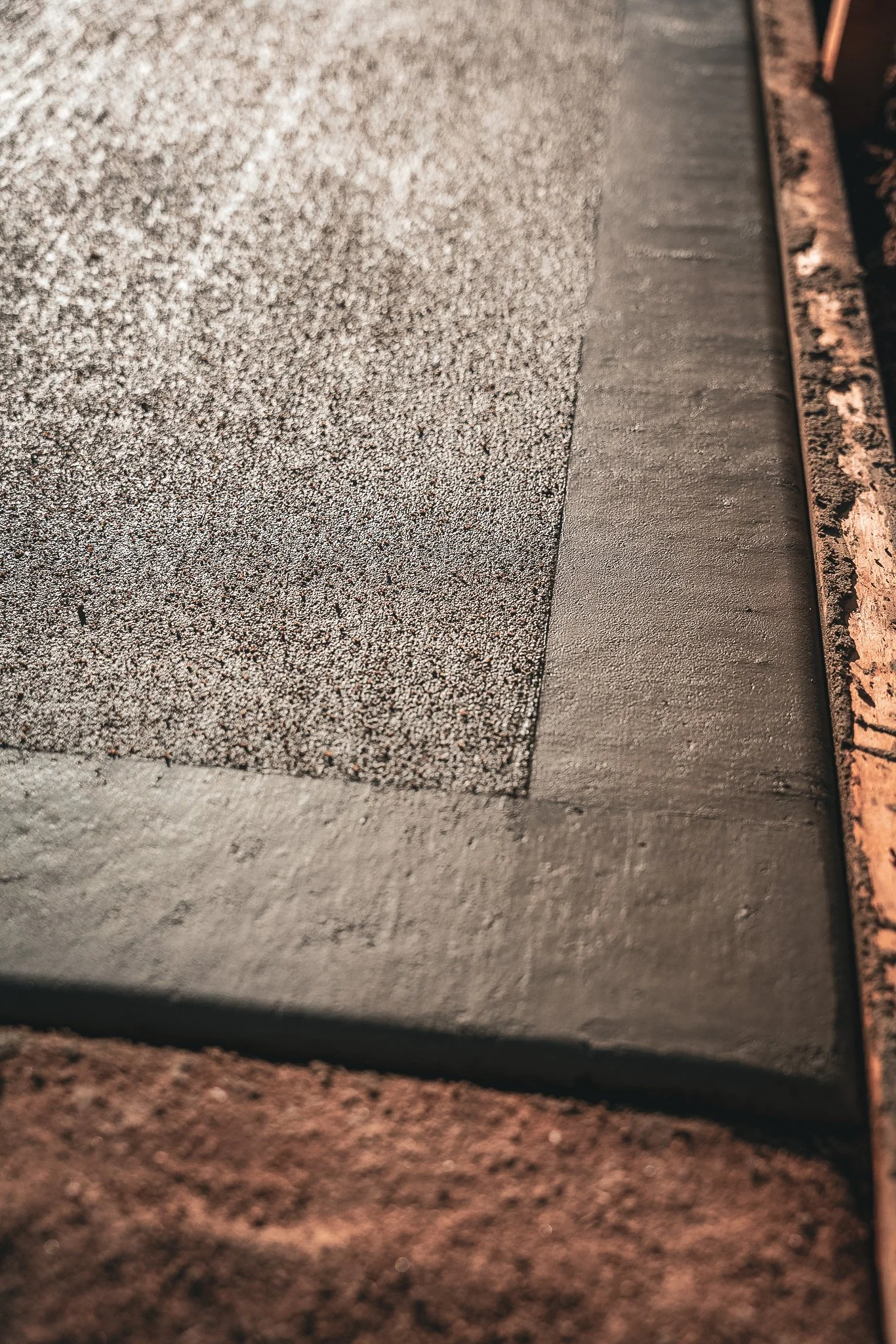 Close-up of a textured black surface with a smooth, flat section next to a rusty metal edge.