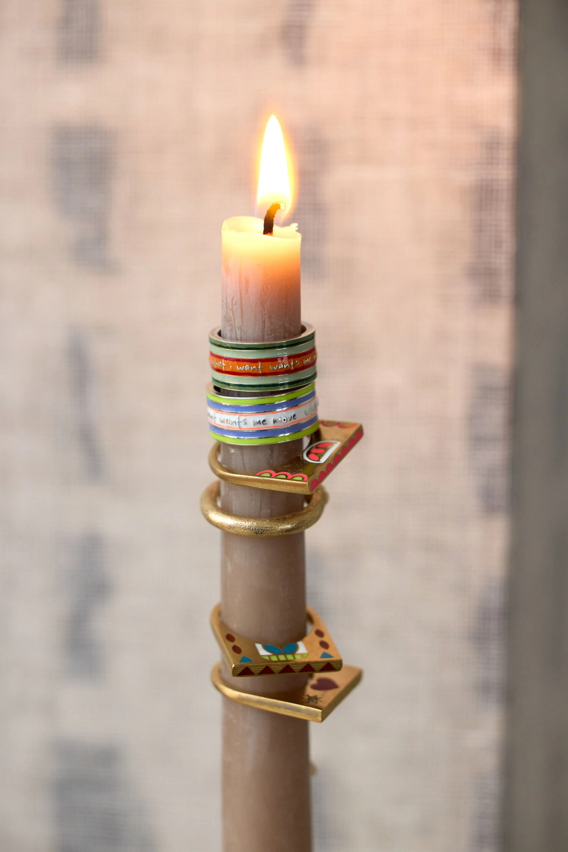 Sterling Silver Cigar Bands and other rings on lit candle, by Elaine Chong Designs