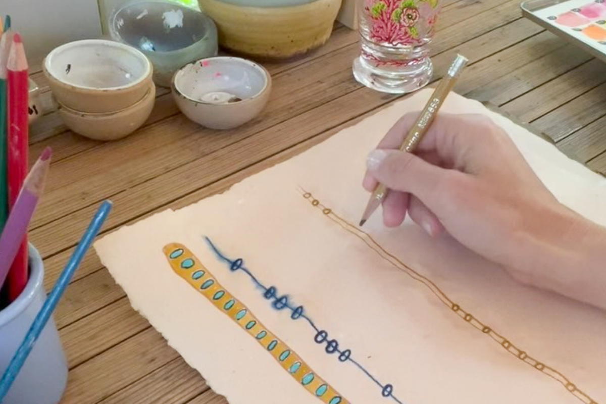 Detail of Elaine sketching out design with pencil in hand