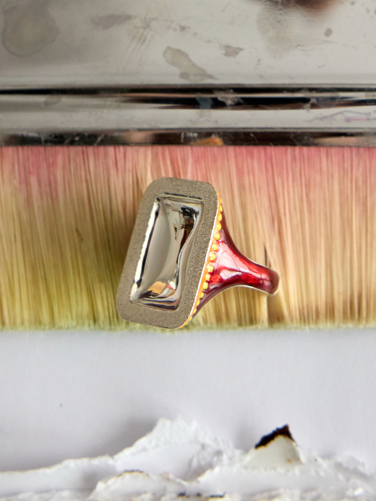 Sterling Silver Enamel Mirror Signet Ring by Elaine Chong Designs, angled side view on paintbrush