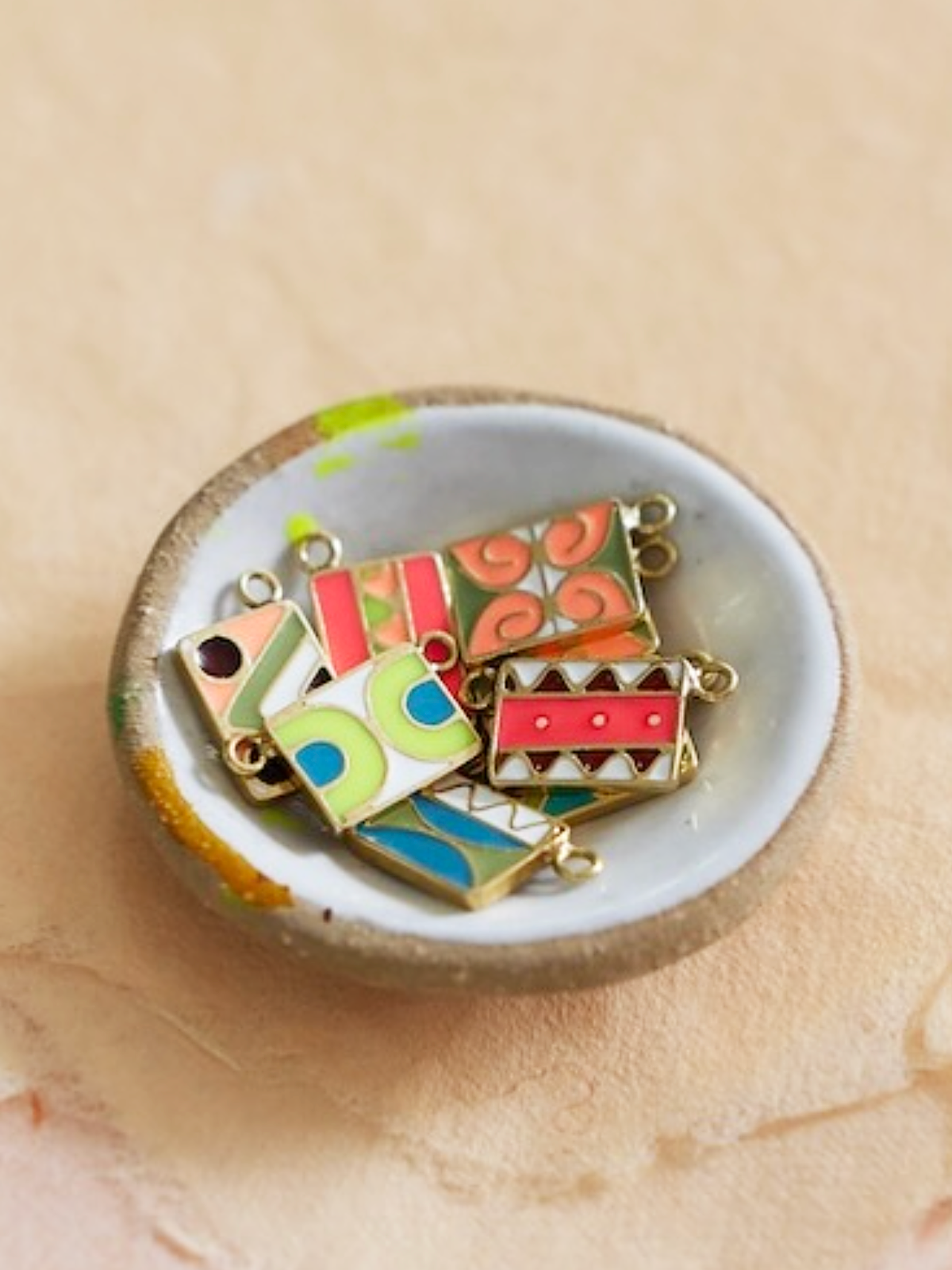 18K Vintage Enamel Tiles on Chain (Website Exclusive) by Elaine Chong in a small jewelry dish