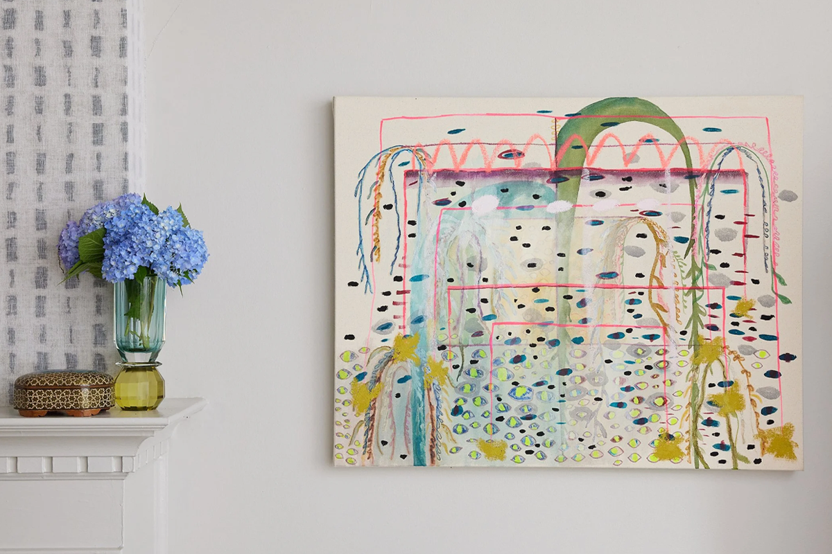 Elaine Chong's painting on wall next to shelf with blue flowers