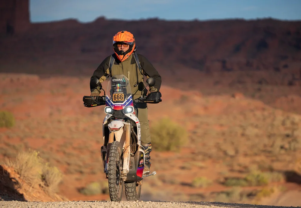 A rider on a Kove 450 Rally on a gravel road in the Moab desert