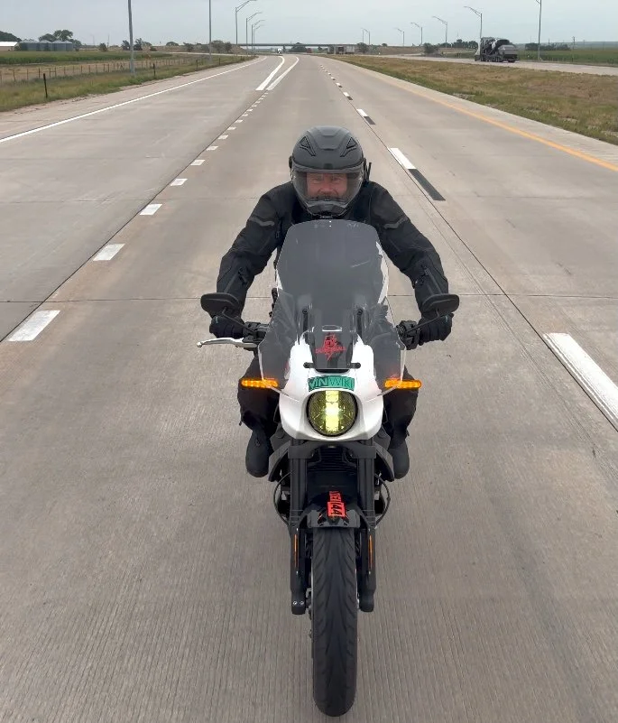 Aaron Pufal drafting the LiveWire a bike length behind the support van, photographed from inside the van.