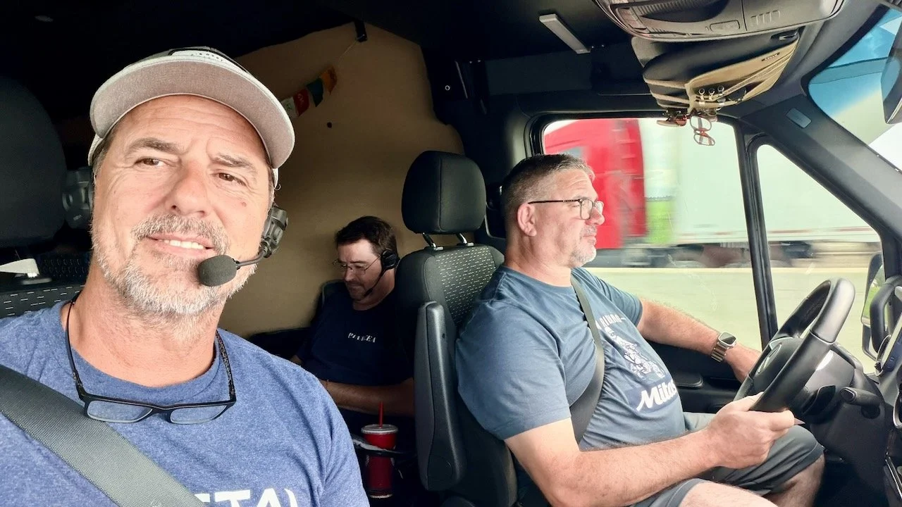 The support crew working inside the Sprinter van on SENA comms, running efficiency numbers in real time.