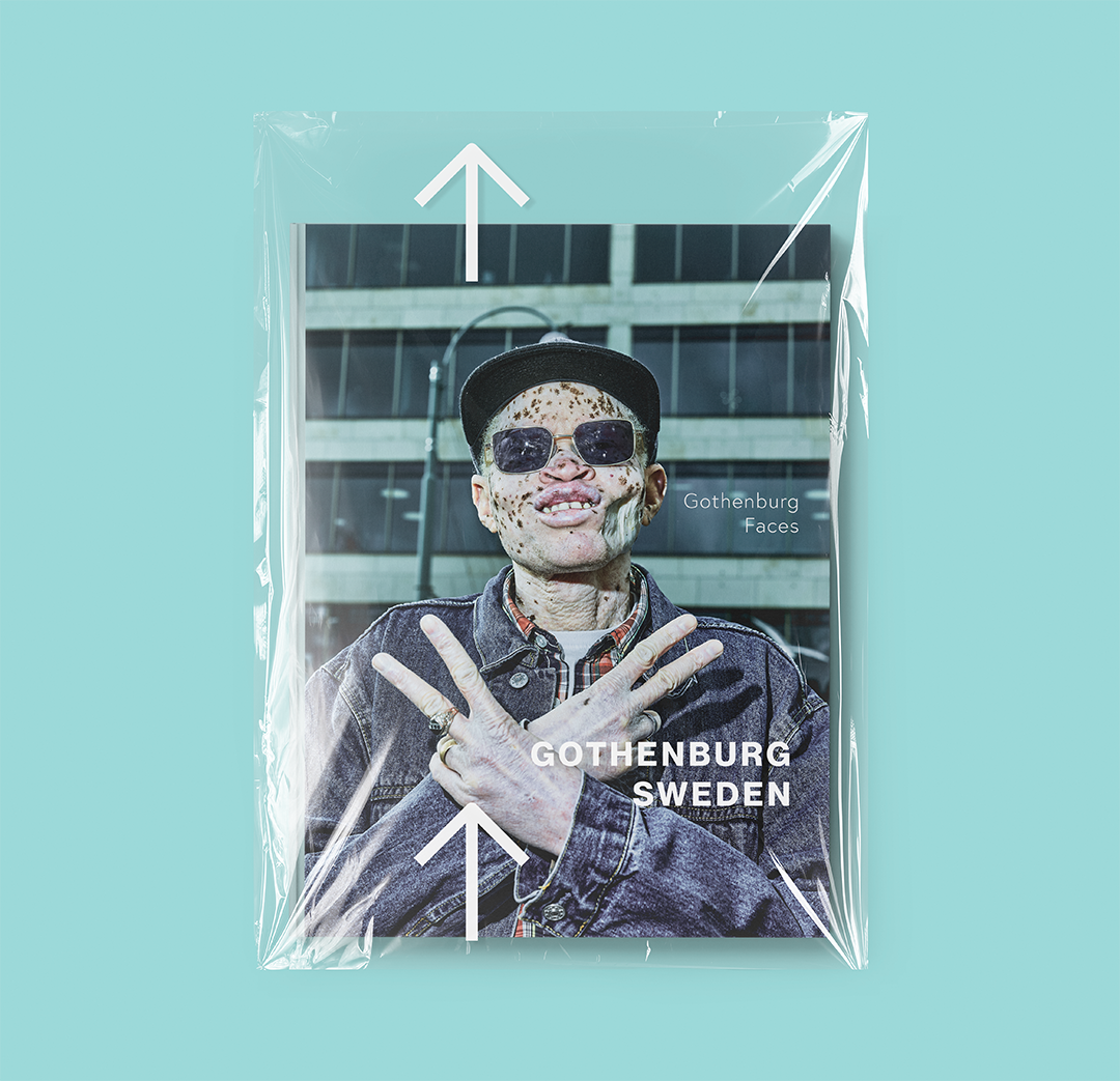 A postcard featuring a person with freckles wearing sunglasses, a hat, and a denim jacket, making a peace sign with their fingers. The background shows a modern building, and the postcard has text that reads "Gothenburg Sweden" and "Gothenburg Faces".