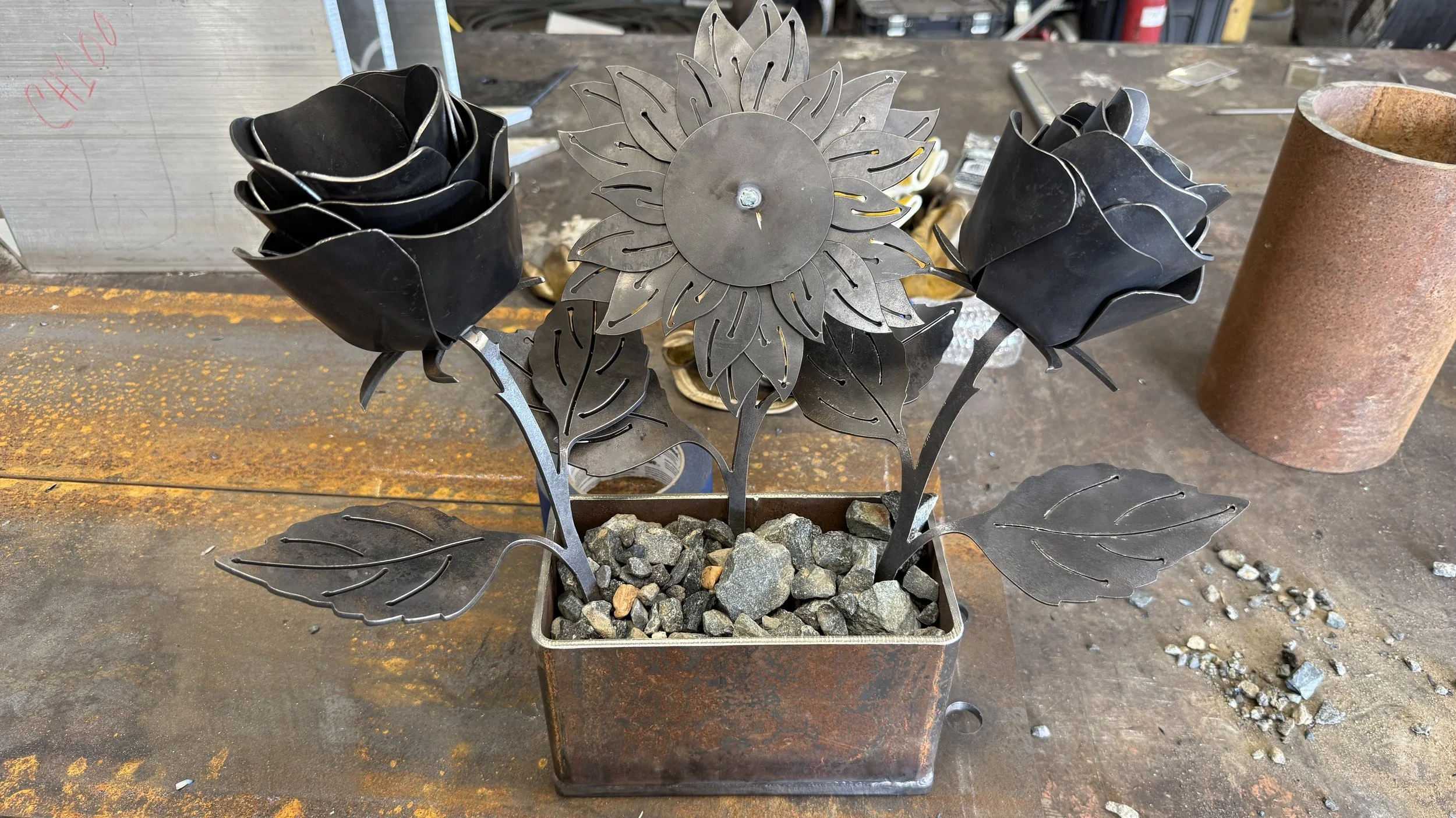 Two metal roses with metal sunflower in rectangular box