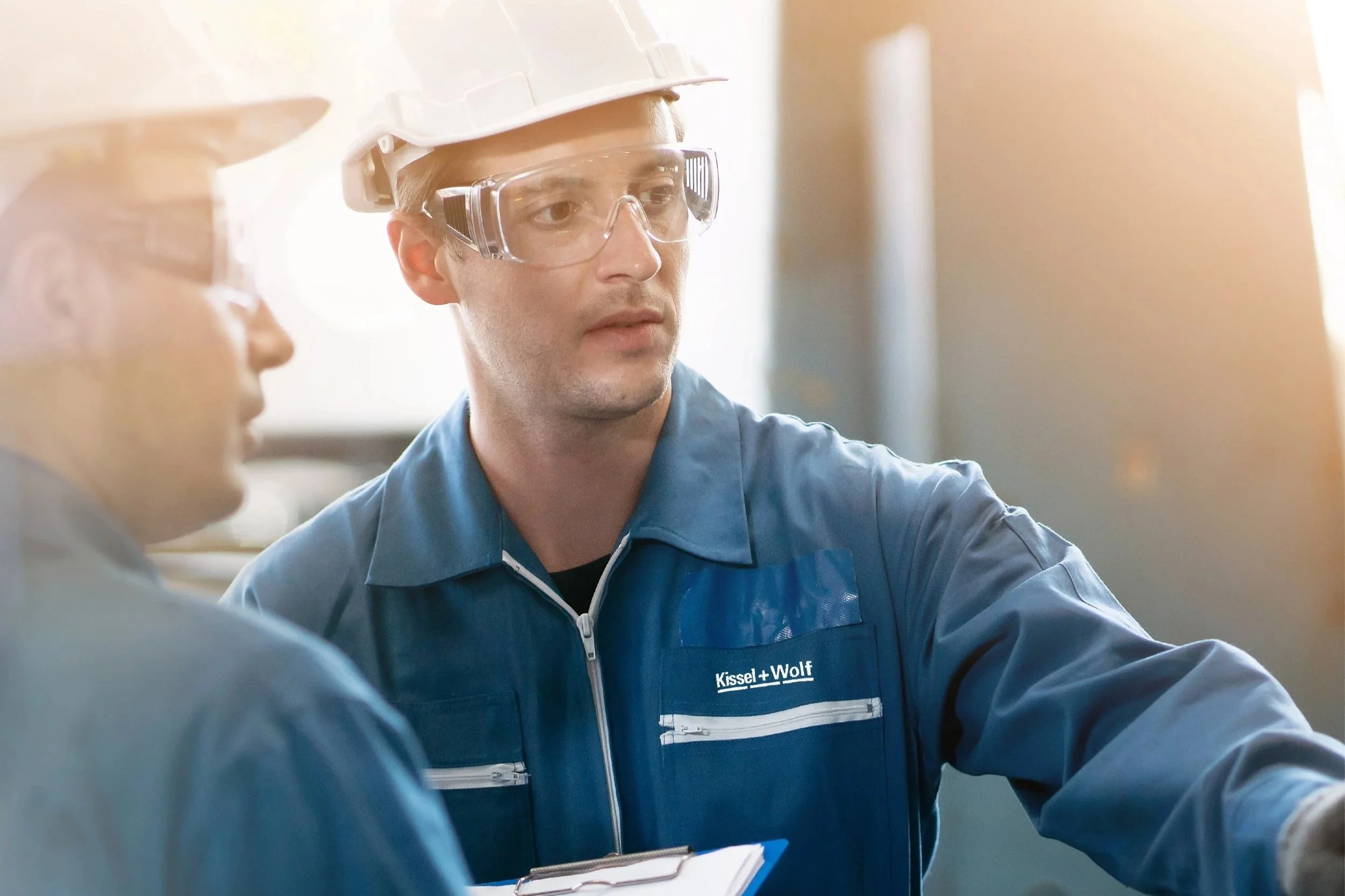 print production operator reviewing process during workflow handover showing communication and coordination in production environment