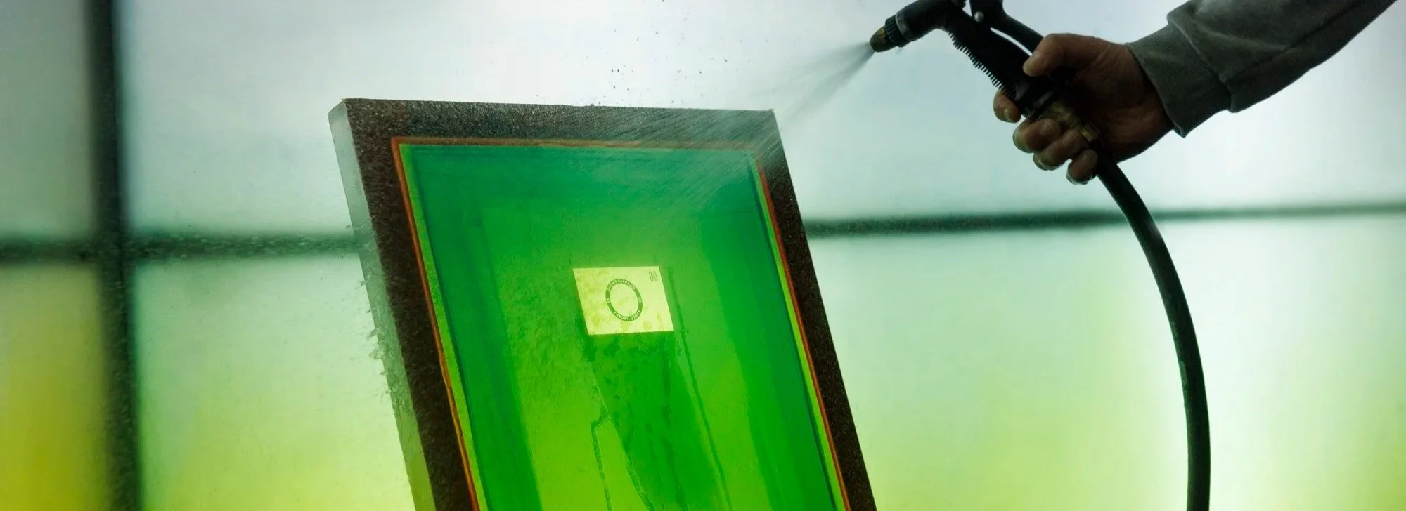 A Screen Frame being washed out by a hose