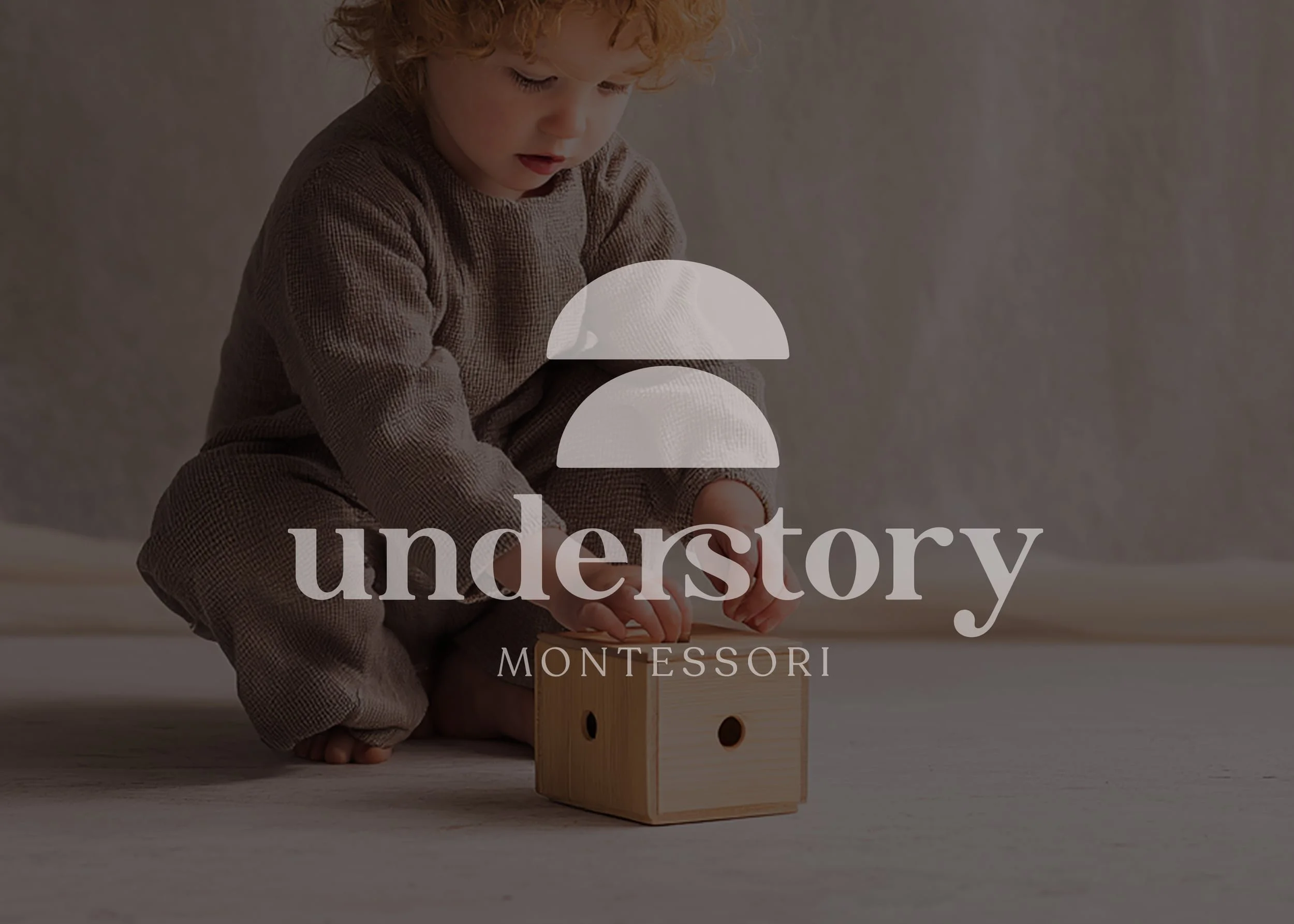 small child putting block into wooden box