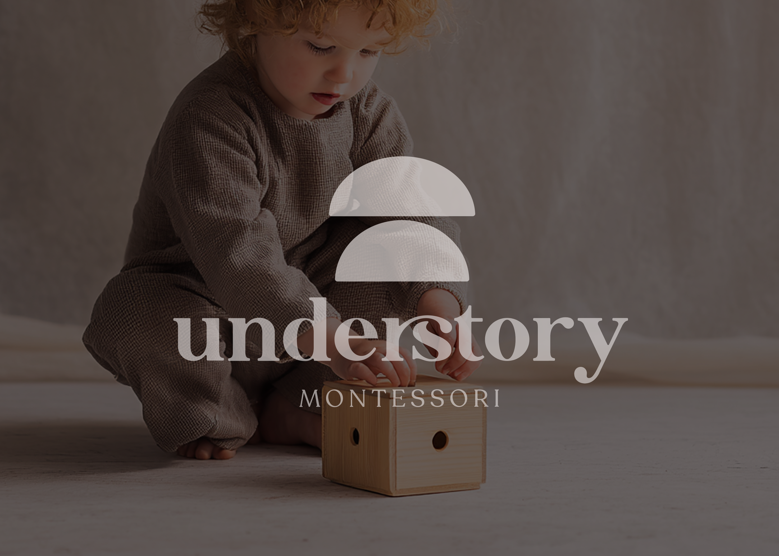 small child putting block into wooden box