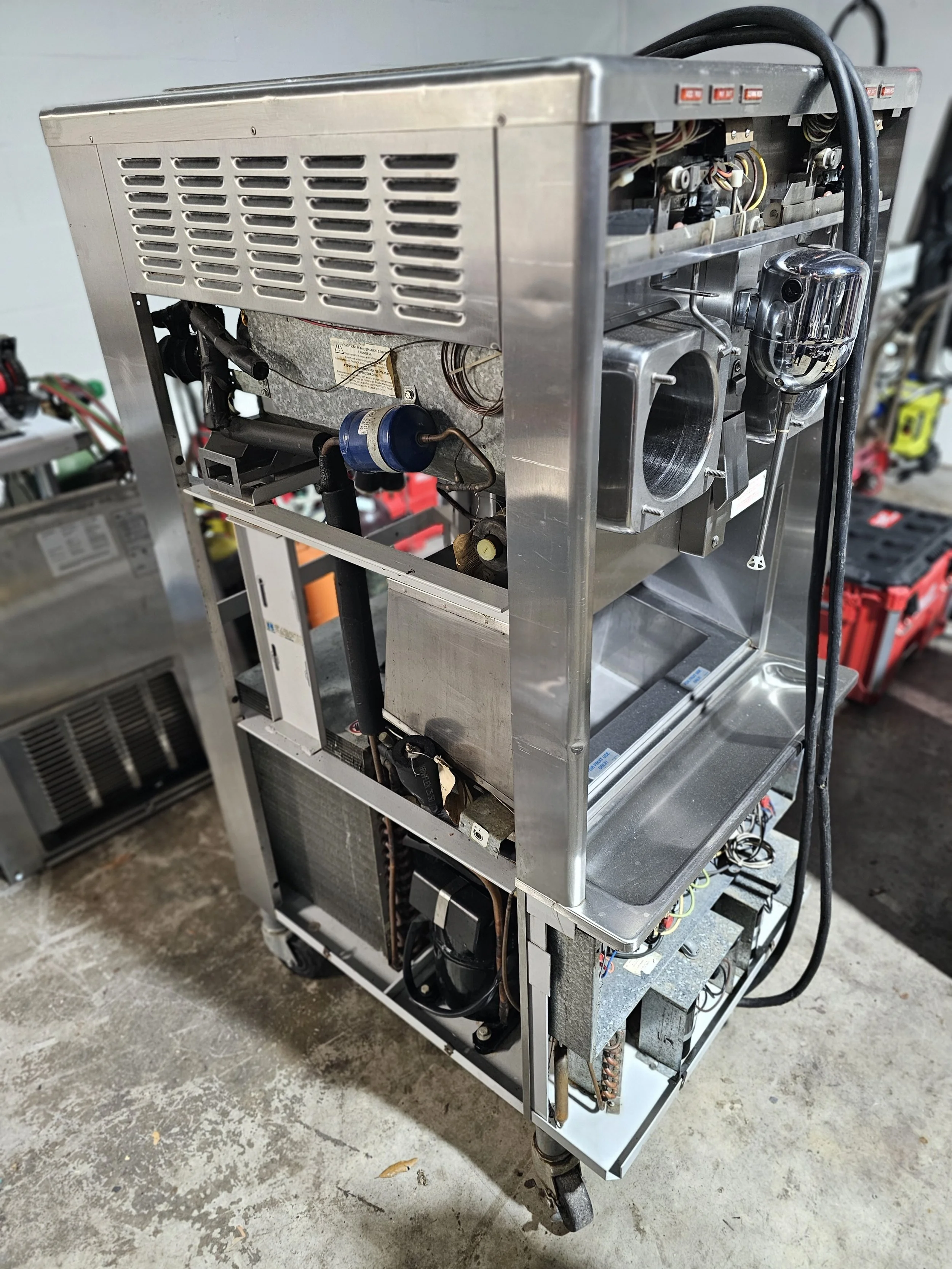 Scenic landscape of a lake surrounded by rolling hills and mountains under a cloudy sky.