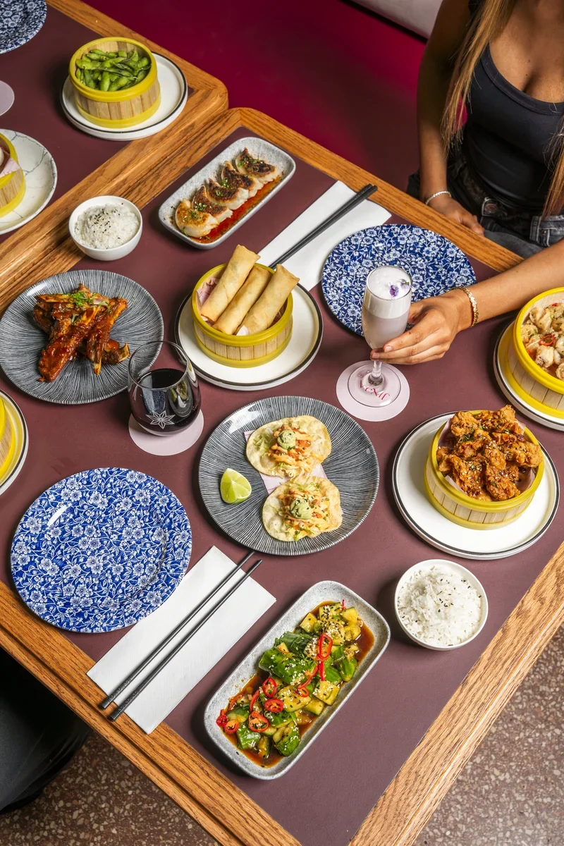 Spring rolls, dumplings and other sharing plates on a Jinja dining table.