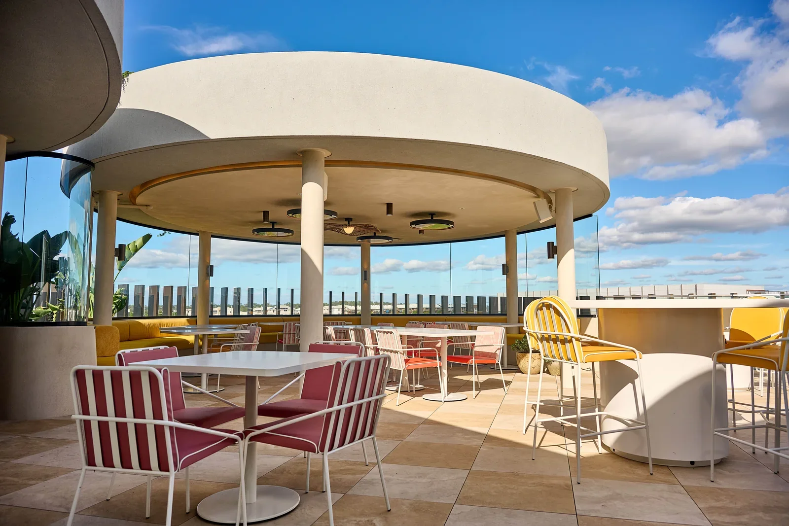 Jinja rooftop terrace with a round shade canopy, tables and outdoor seating.