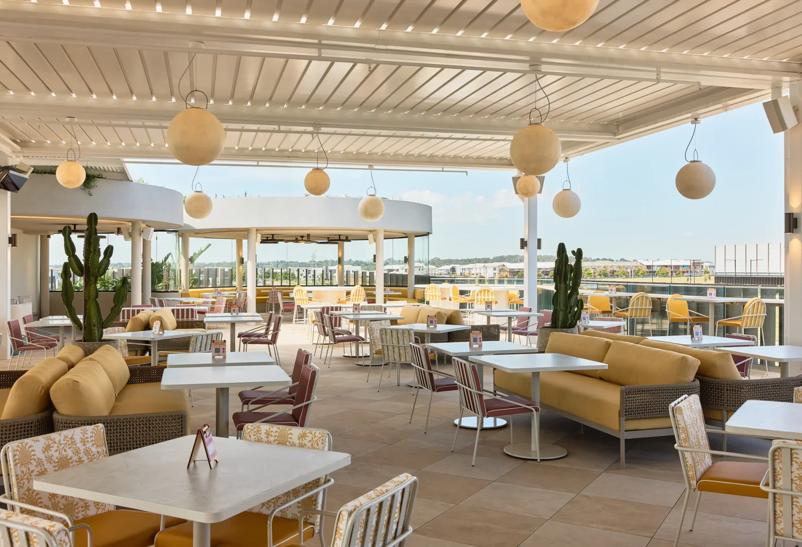 Jinja rooftop terrace with a pergola, yellow lounges and open skyline views.