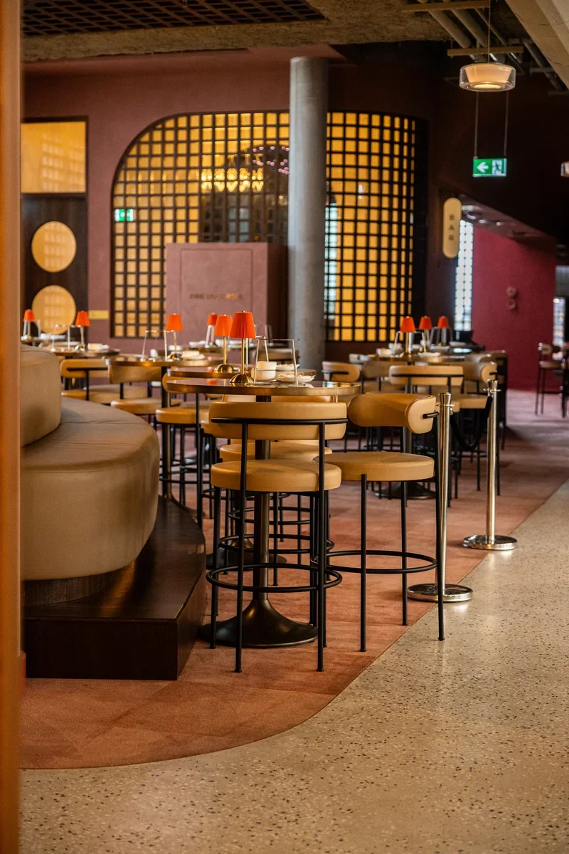Jinja dining room with tables set beneath warm arched wall details.
