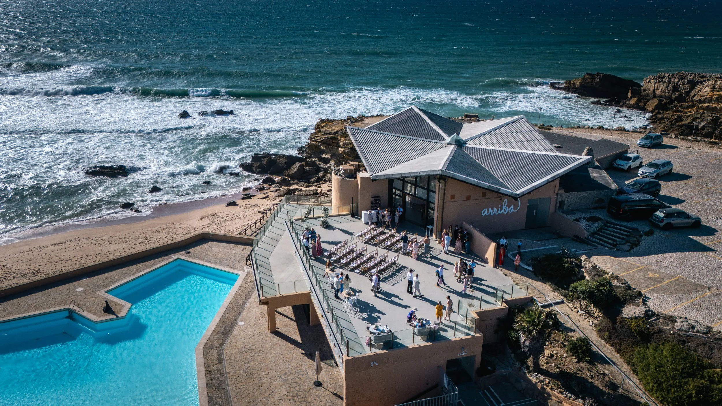 Aerial drone view of a seaside venue with pool, beach and cliffs, Portugal