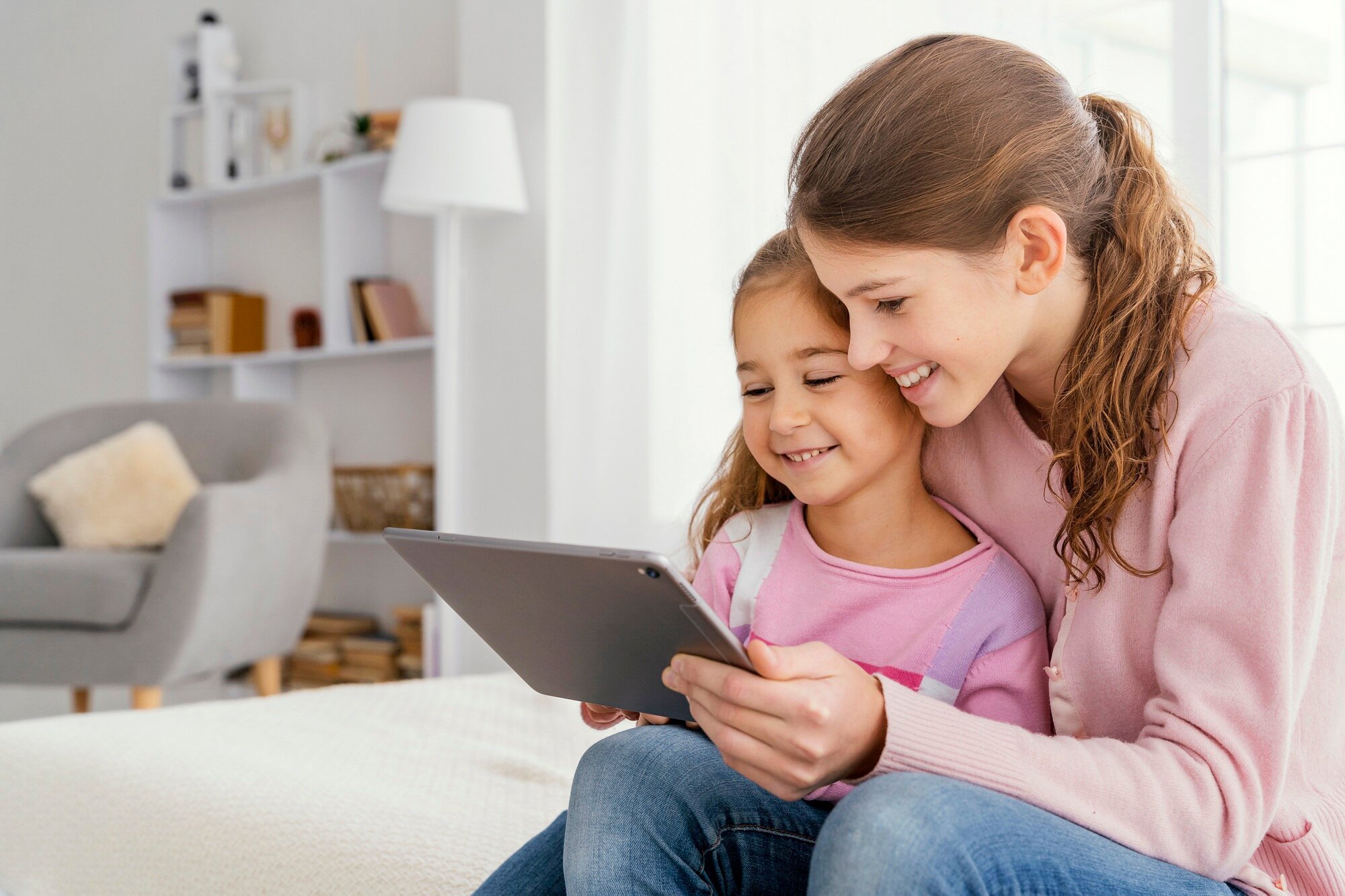 two-smiley-sisters-together-home-using-tablet_23-2148890922.jpg