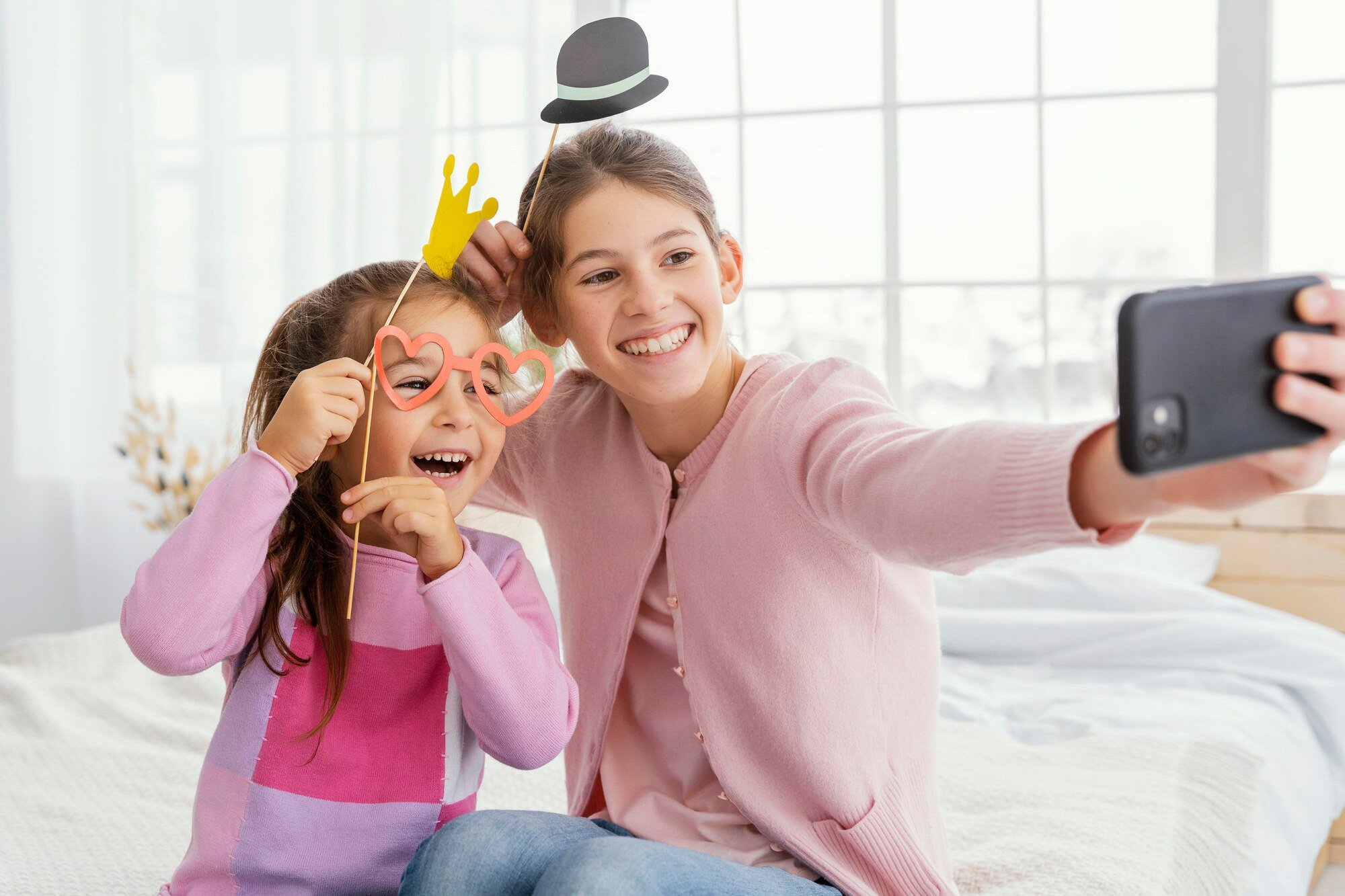 front-view-two-sisters-home-taking-selfie_23-2148890924.jpg