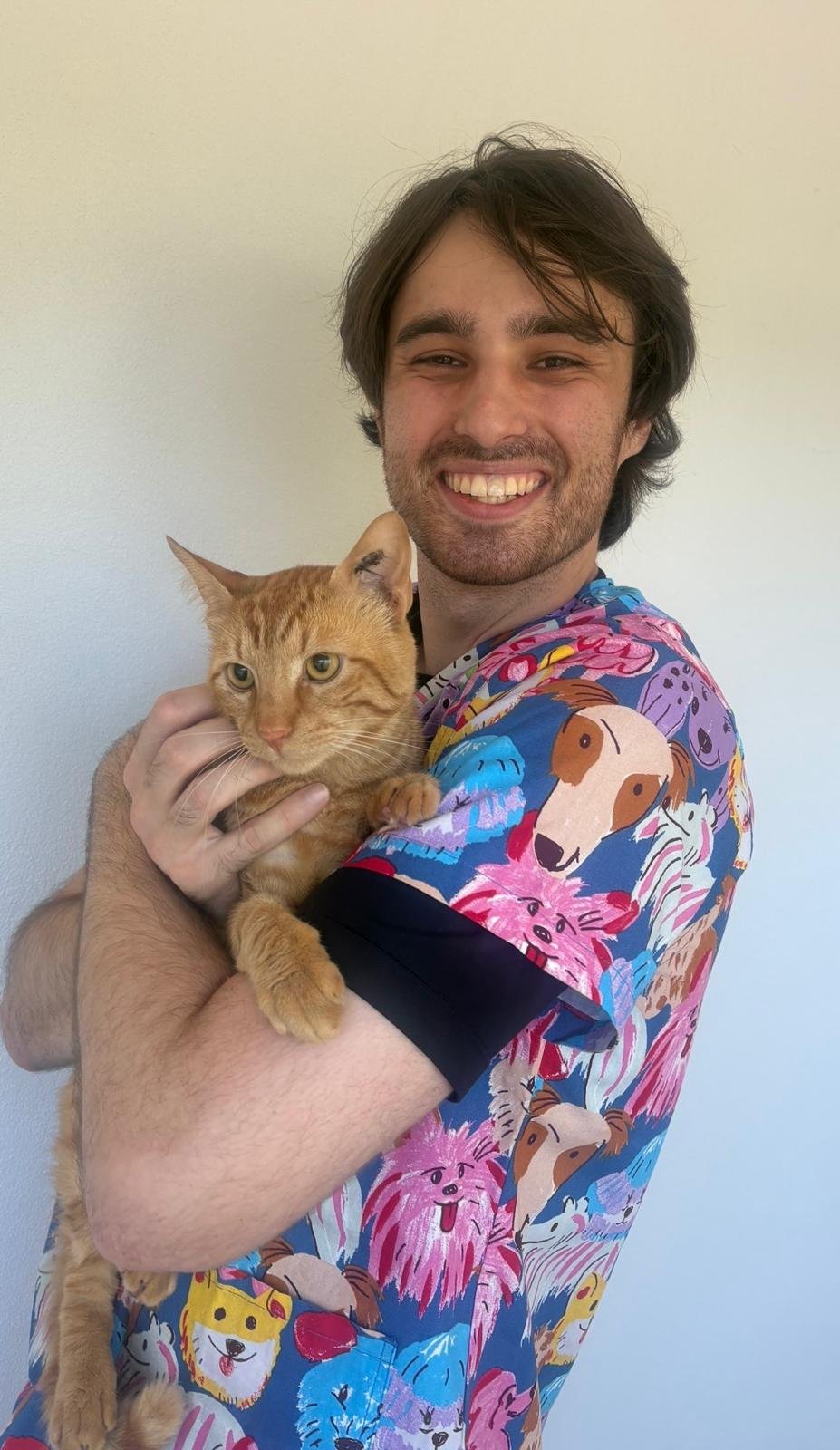 Chad, vet nurse at My Corner Vet Nedlands, holding a ginger cat