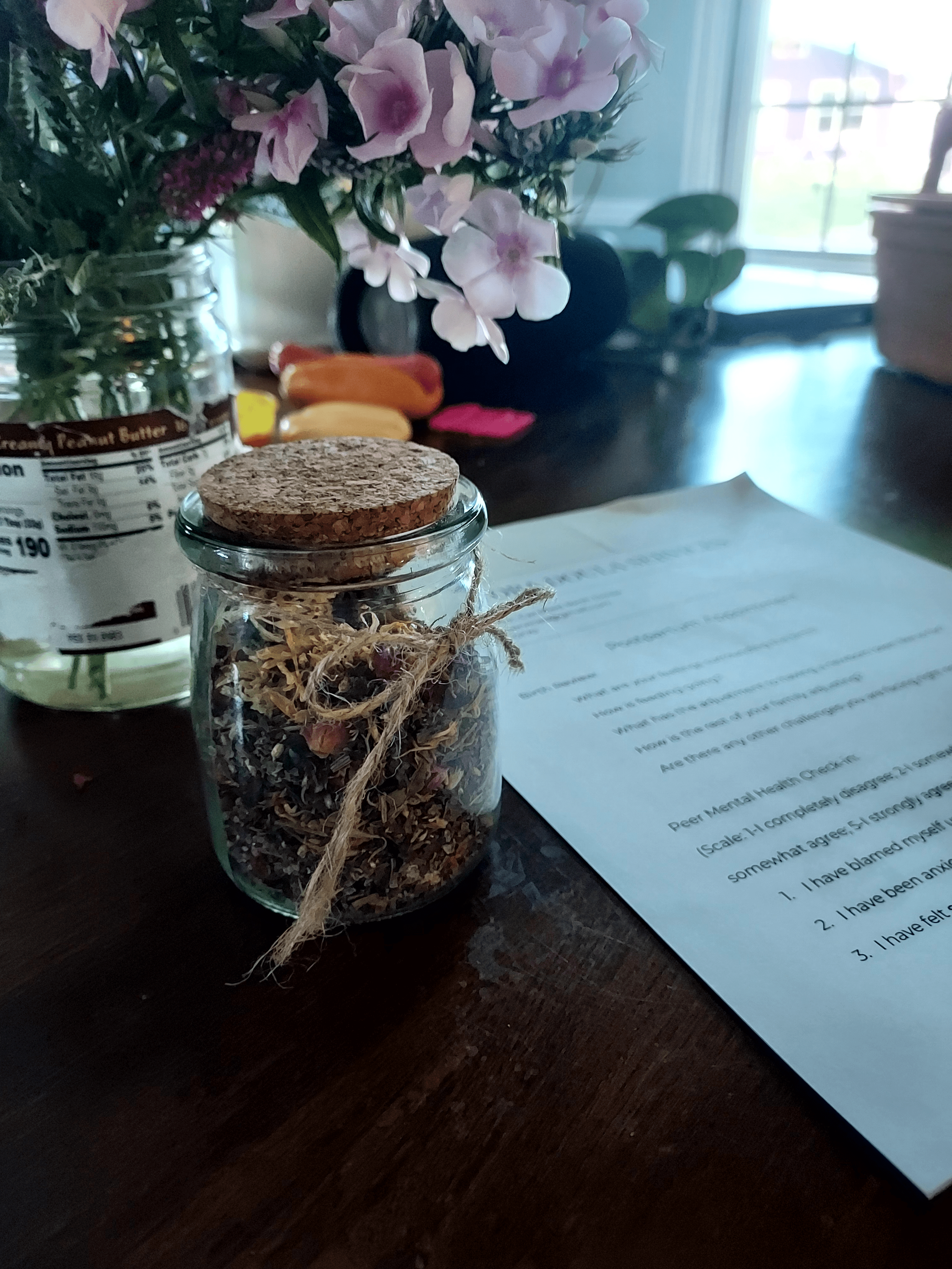 homemade postpartum herbal bath soak in a jar beside paper postpartum care instructions