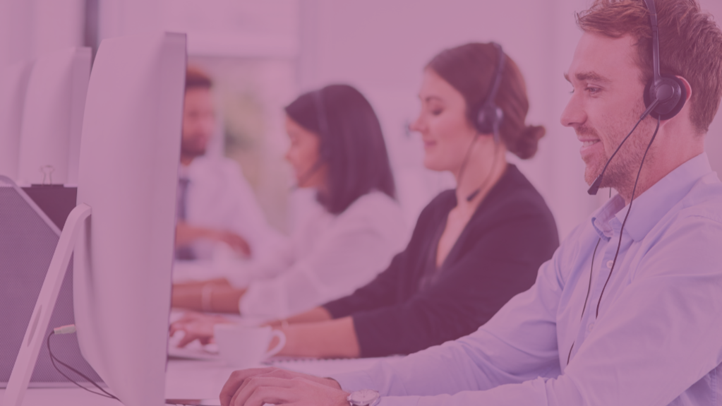 Customer service representatives wearing headsets working at computers in an office.