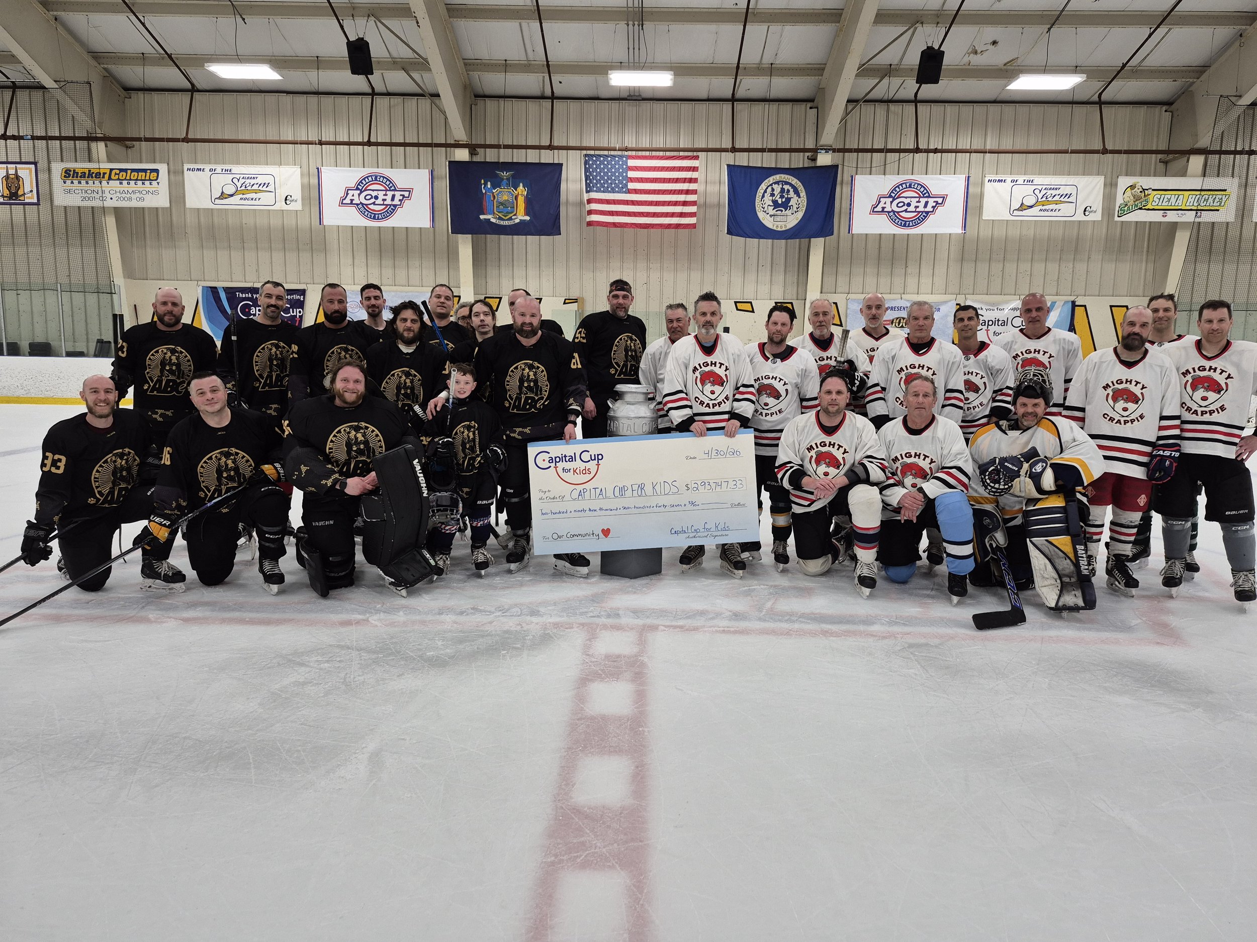 two teams displaying a check raised from a hockey tournament