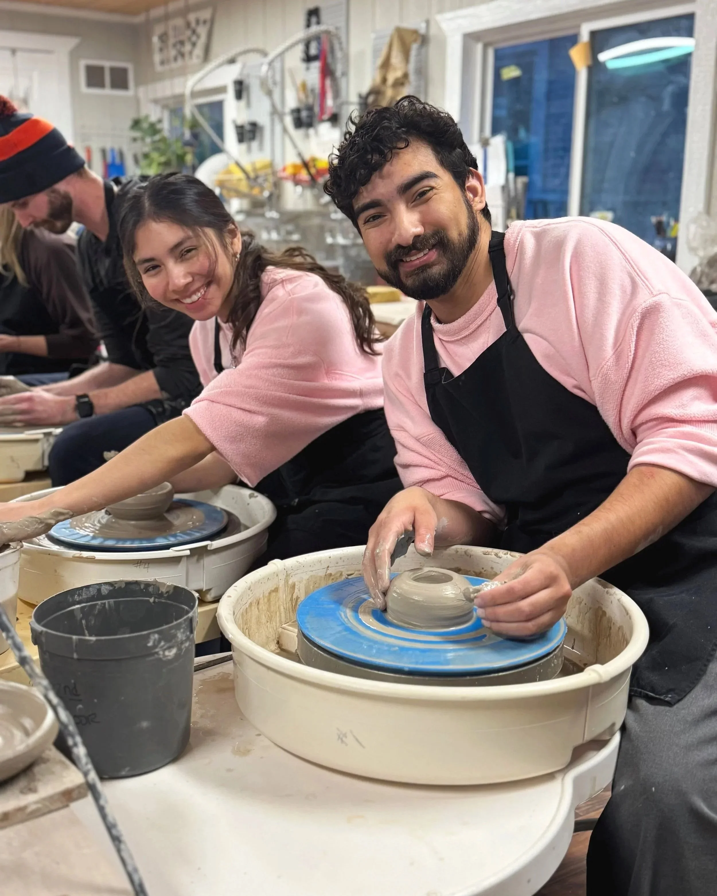 Two people smiling while working on pottery on a wheel in a ceramics studio, with other people and tools in the background.
	•	pottery birthday party Frisco TX
	•	private pottery class near me
	•	pottery party for adults and kids
	•	bachelorette part