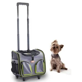 A pet carrier on wheels with a small dog sitting beside it.