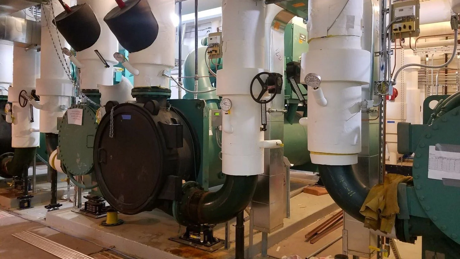 Industrial machinery with pipes, gauges, and valves in a factory setting.