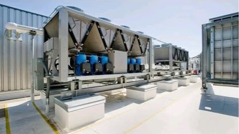 Industrial HVAC rooftop air conditioning units with large fans and metal casings.