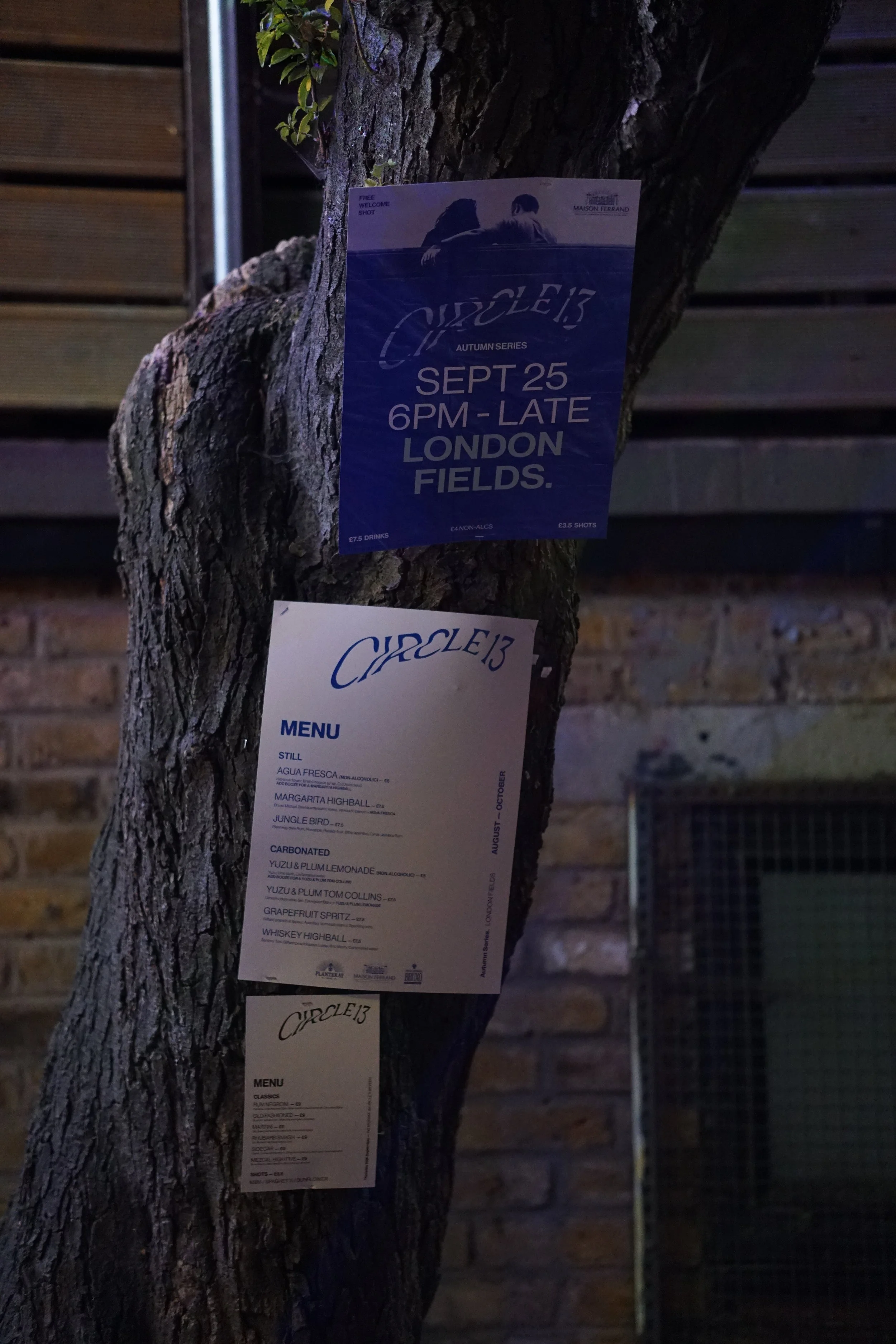 A circle13 event flyer posted on a tree in London Fields