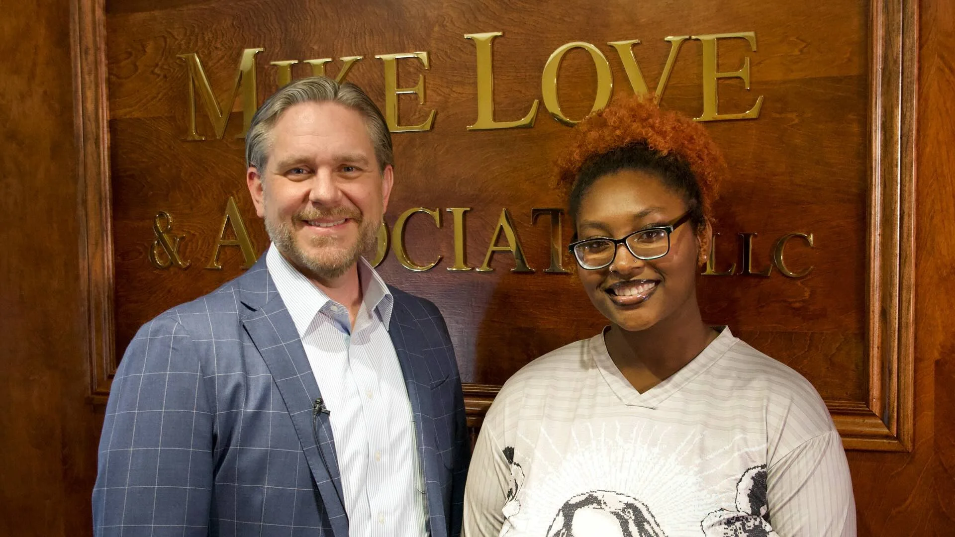 Sam Johnson, Managing Partner of Mike Love & Associates, LLC, presents McKenzie Dixon of Lufkin High School with the Mike Love High Five Scholarship at the firm's office in Lufkin, TX.