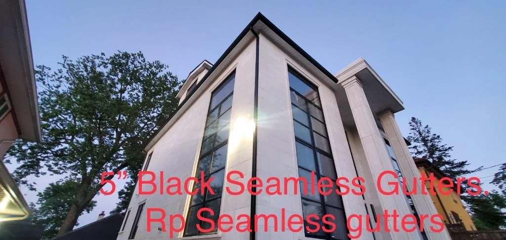 Photo of a modern home with large black seamless gutters and downspouts, taken after work was done.