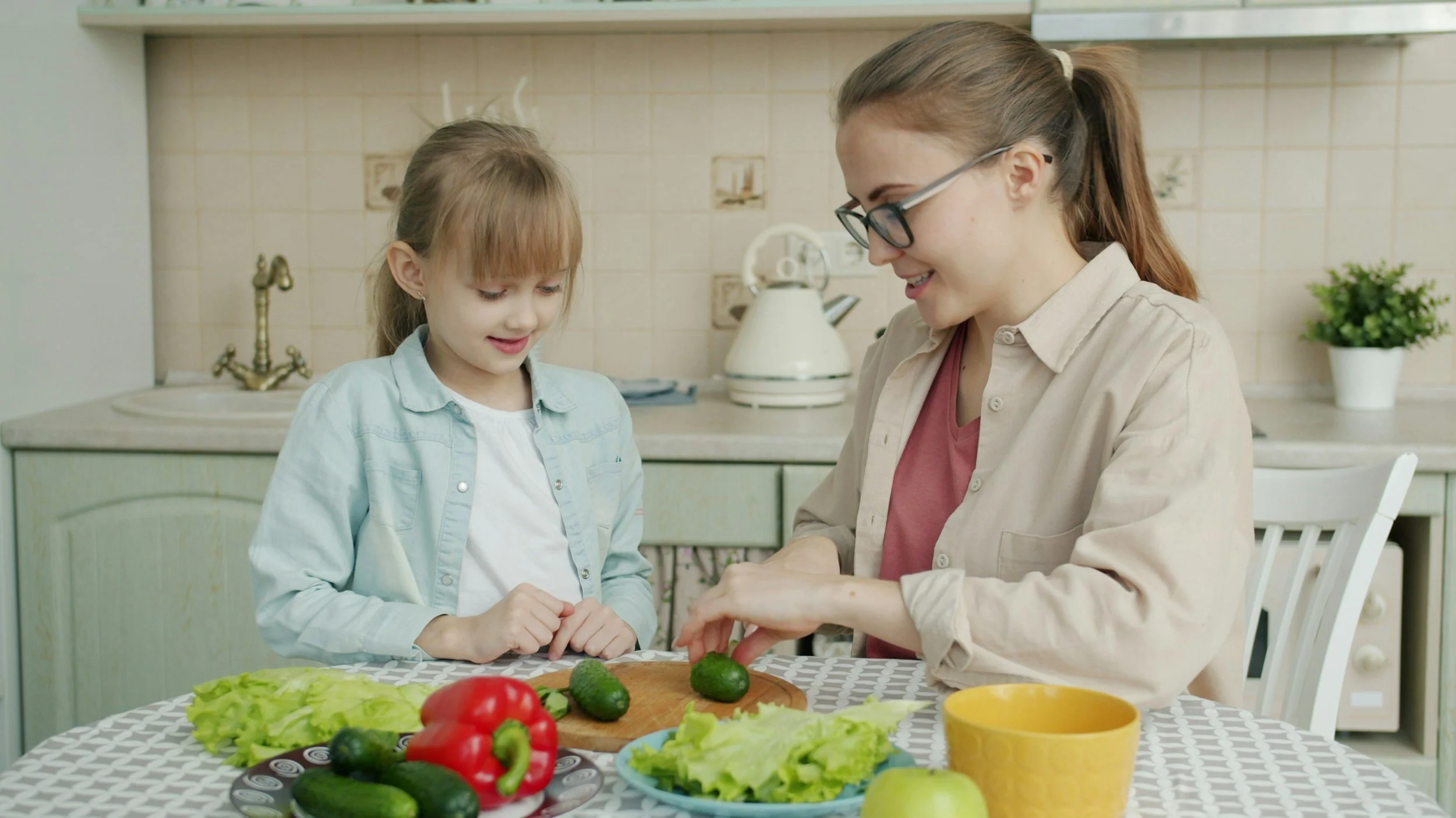 mom and daughter in kitchen cutting up vegtables
