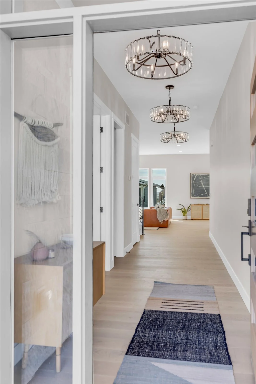 Entry hallway with a patterned runner and three glass chandeliers