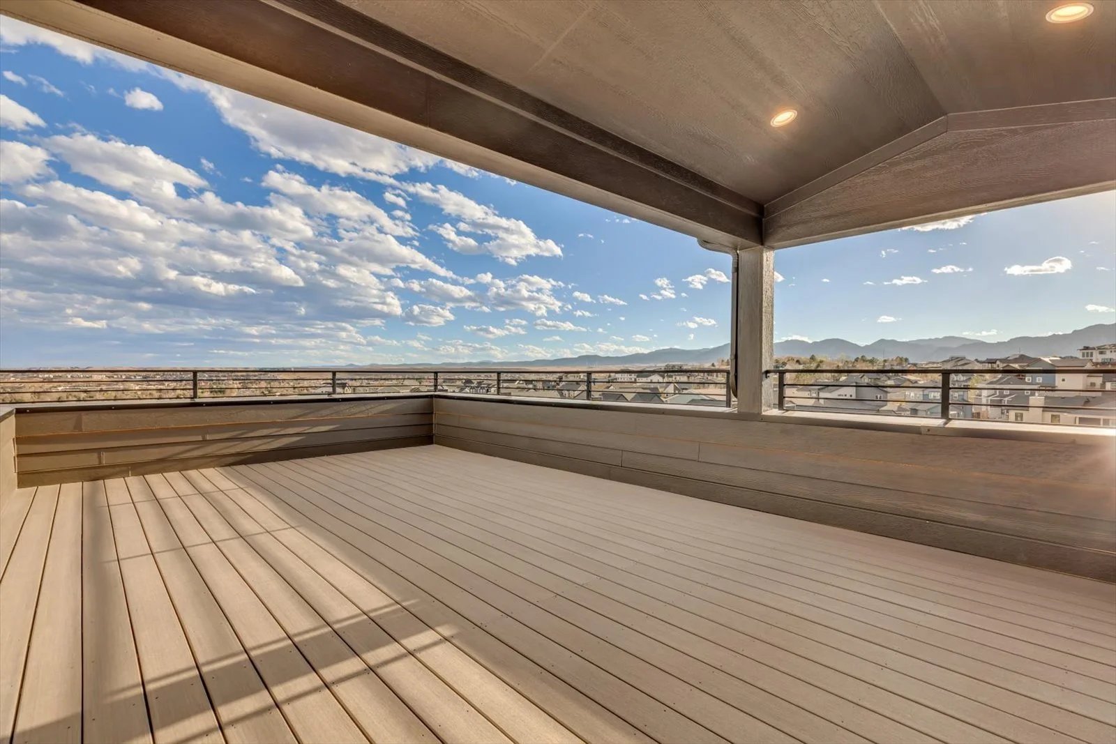 Covered upper terrace with black railings and an open mountain view