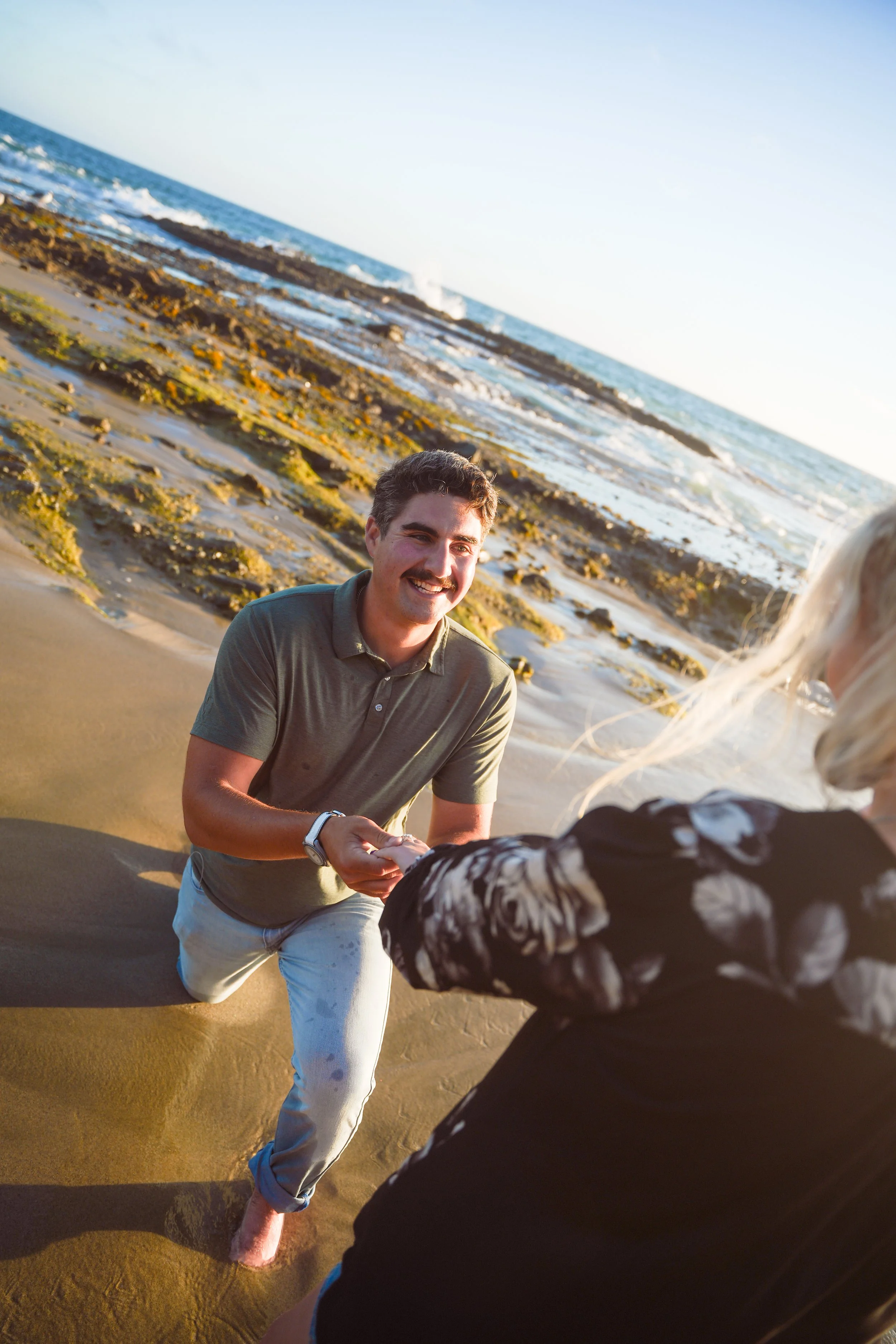 A heartfelt surprise proposal unfolds at Victoria Beach in Laguna Beach as the sun sets over the Pacific Ocean.