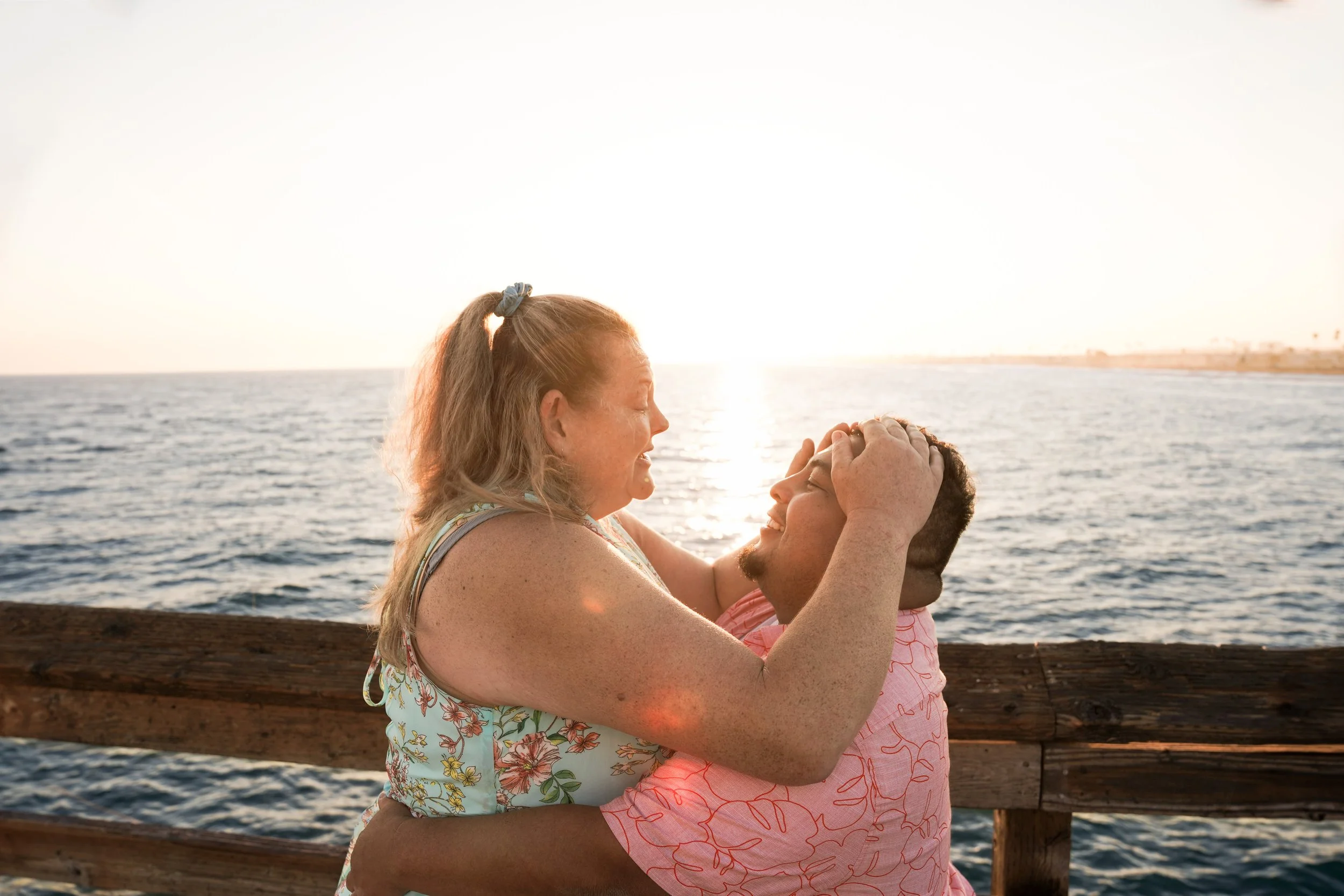 Newport Beach engagement photographer captures romantic Balboa Pier surprise proposal with Jennifer saying yes to Miguel’s question.