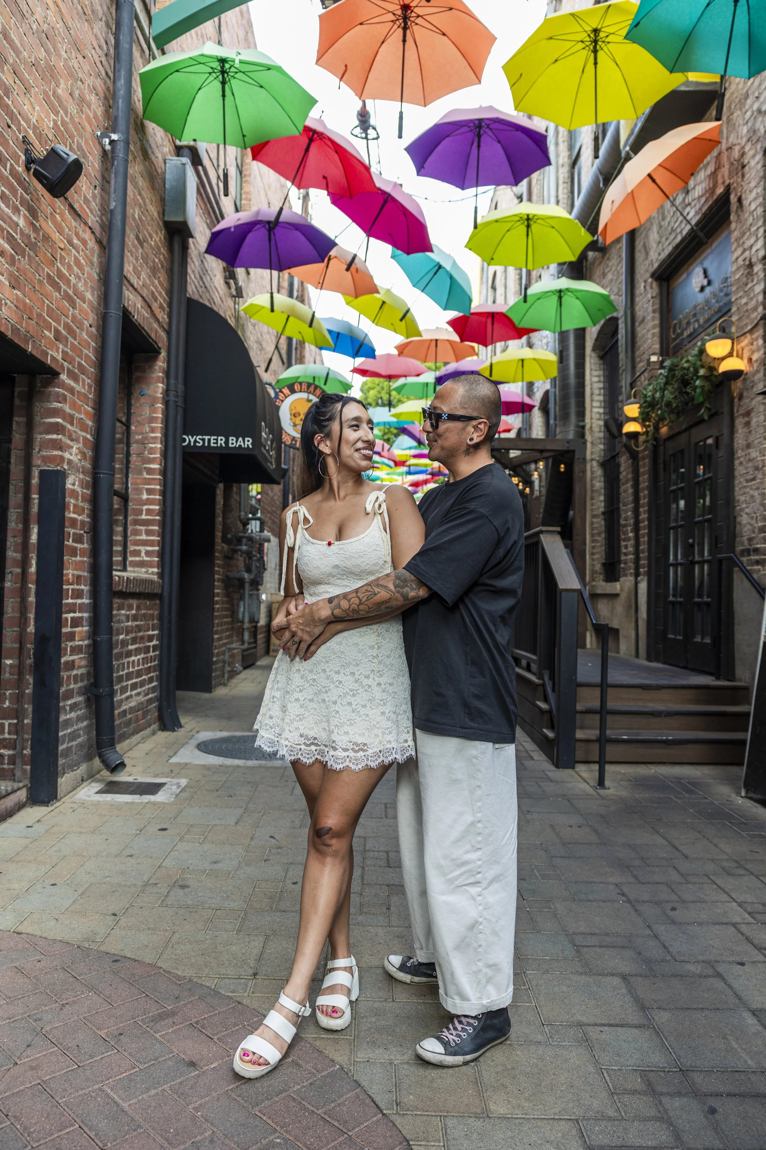  Candid couple laughing together during a milestone anniversary photo session in downtown Redlands. 