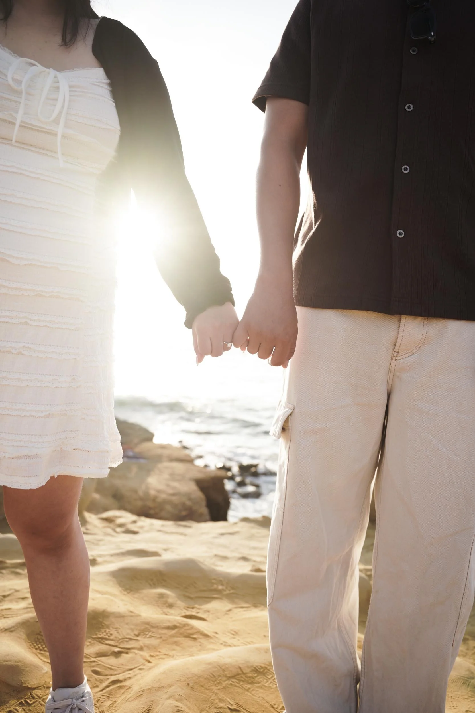 Romantic Sunset Cliffs San Diego proposal photography session highlighting candid reactions, engagement portraits, and golden hour magic.