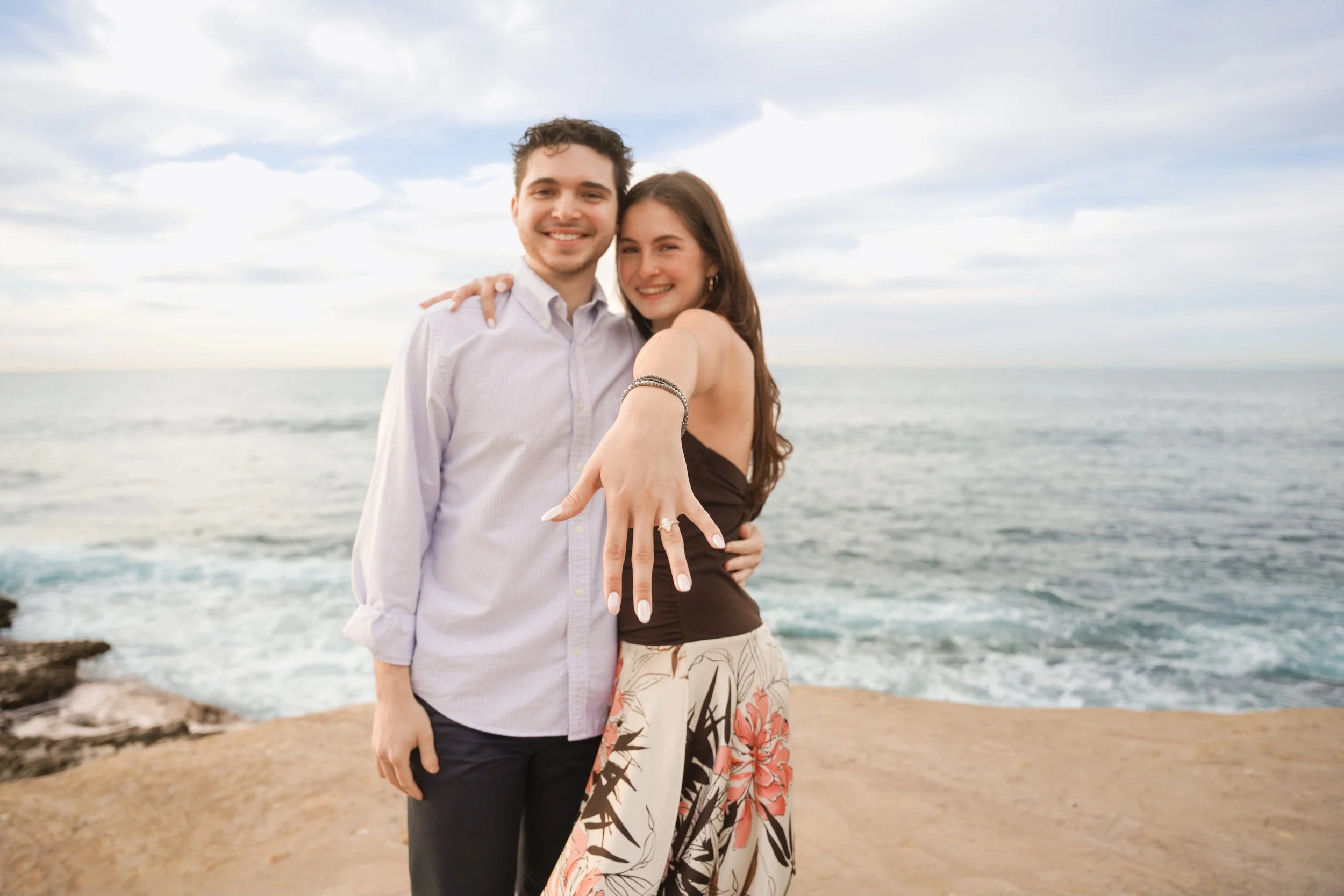 Surprise proposal on the bluffs at Scripps Park, La Jolla Cove — coastal San Diego engagement photography.
