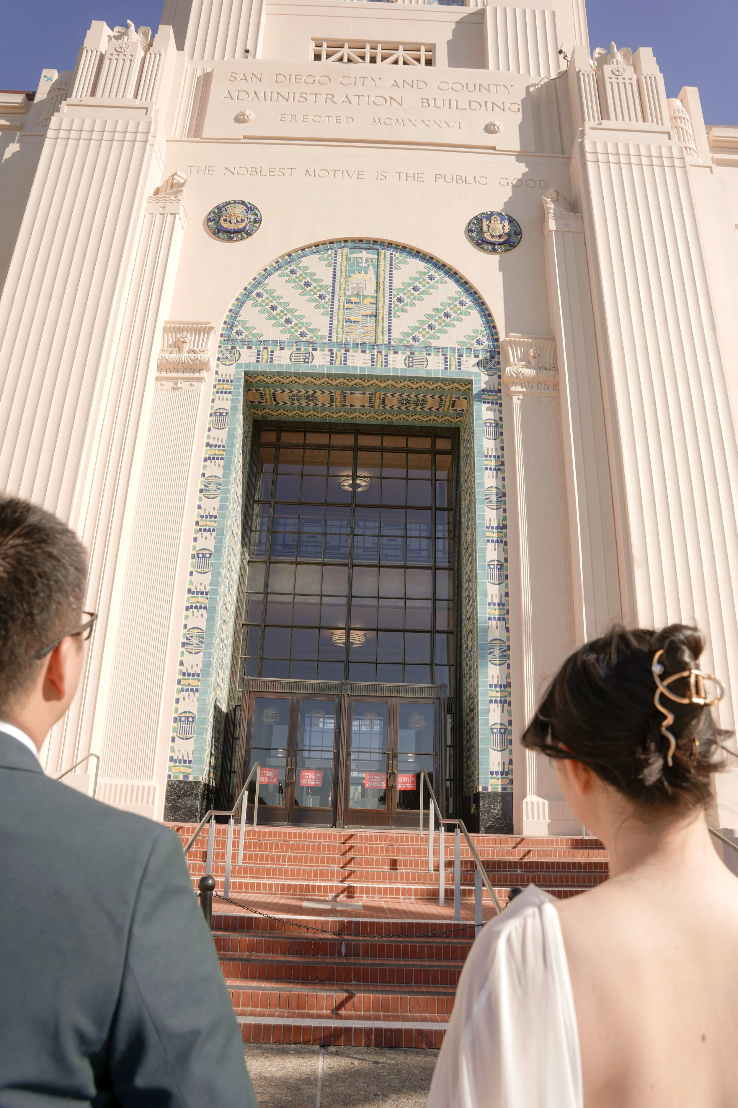 Couple holding hands before entering the San Diego County Administration Building for their courthouse wedding ceremony in downtown San Diego.