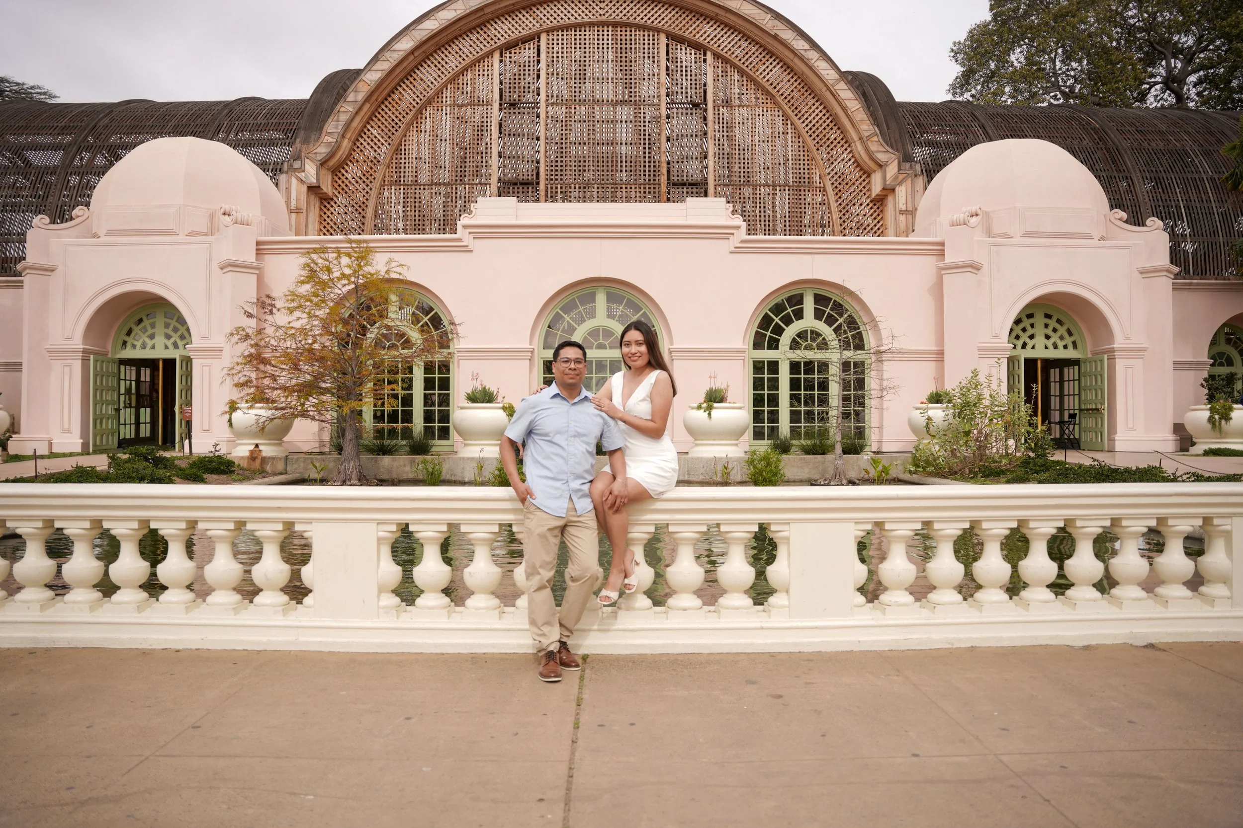 Couple celebrating their engagement at the Lily Pond and Botanical Building in Balboa Park after a surprise proposal photoshoot in San Diego