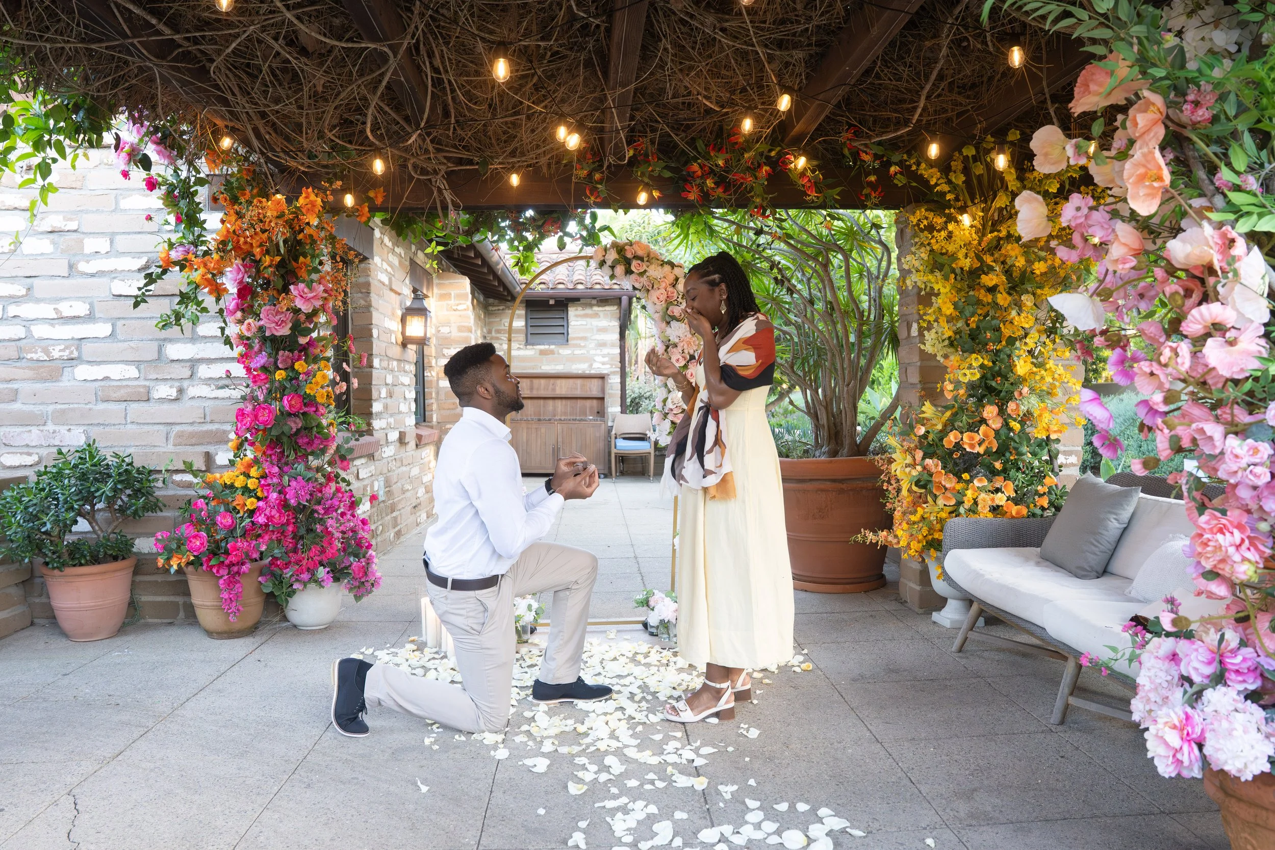 Man proposing on one knee during surprise proposal at Estancia La Jolla Hotel & Spa, La Jolla surprise proposal photographer capturing emotional “yes” moment in San Diego