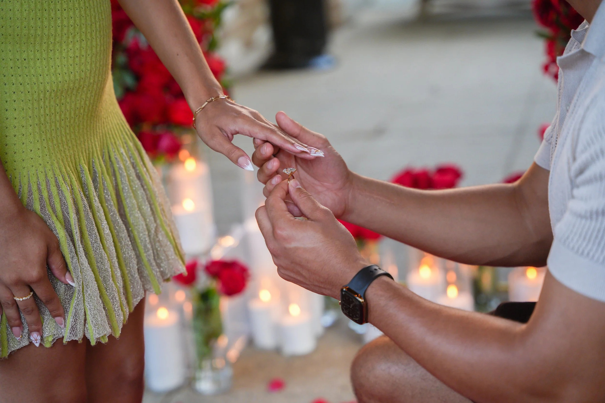 David kneels to place an engagement ring on Leila's finger during their Golden Yes surprise proposal at Point Flora, Estancia La Jolla Hotel & Spa in San Diego, California.