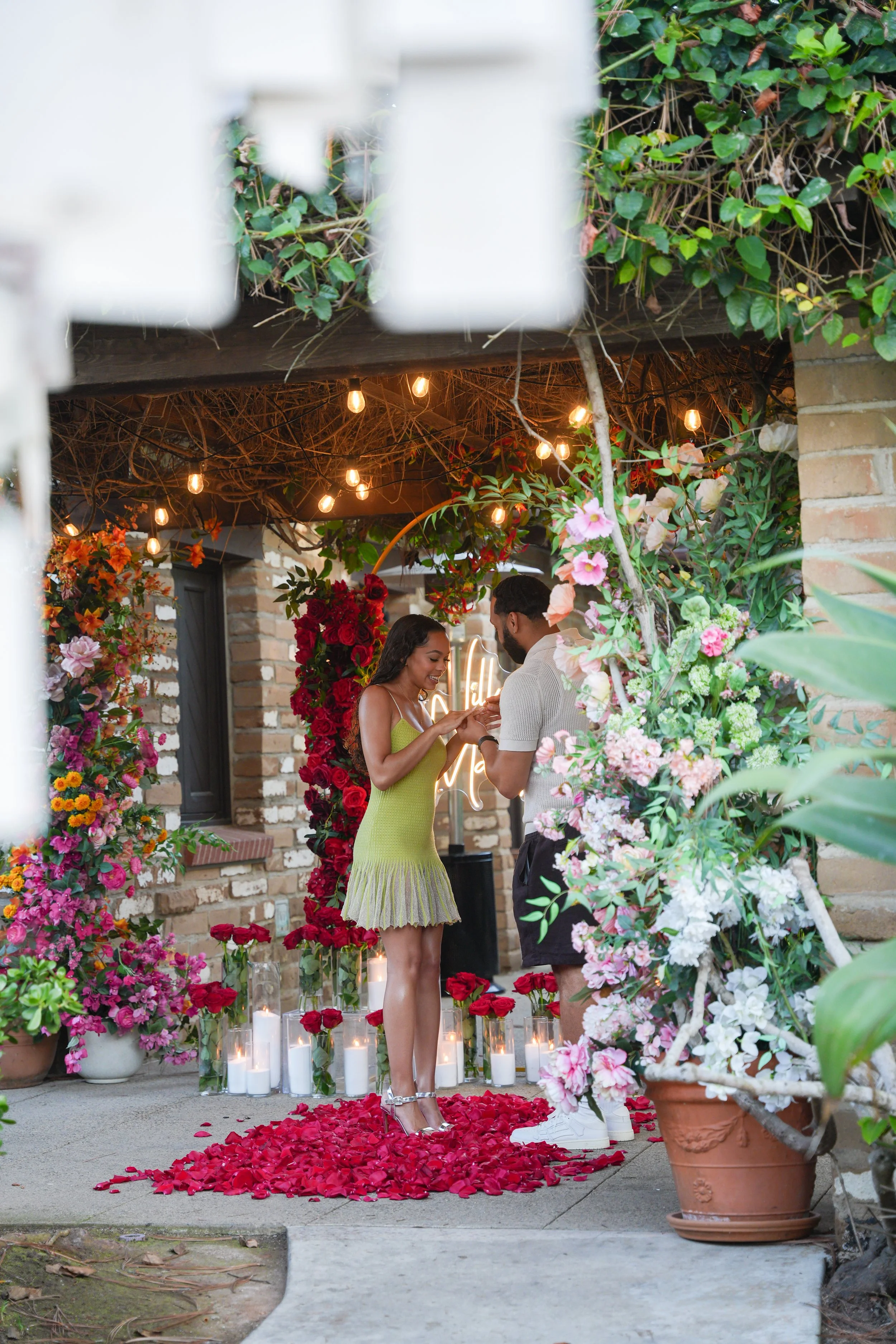 Romantic surprise proposal at Point Flora in Estancia La Jolla Hotel &amp; Spa, surrounded by lush resort gardens.