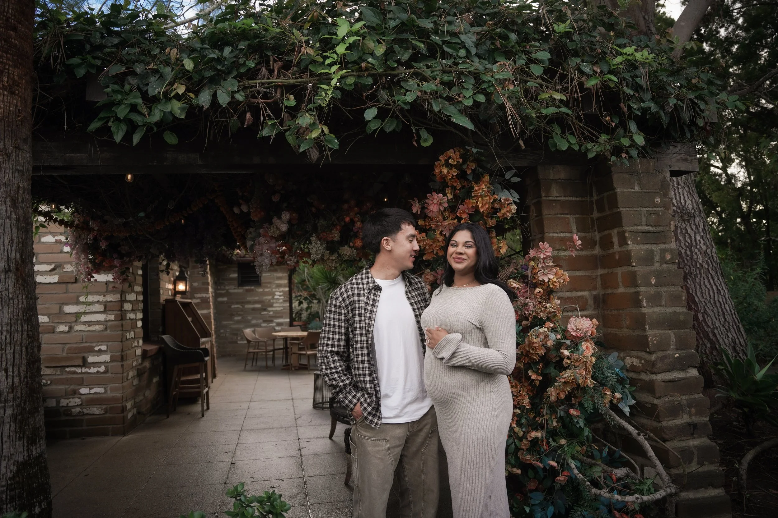 Wide shot of the proposal at Estancia La Jolla’s Wishing Tree, showcasing the romantic garden setting and timeless architecture.