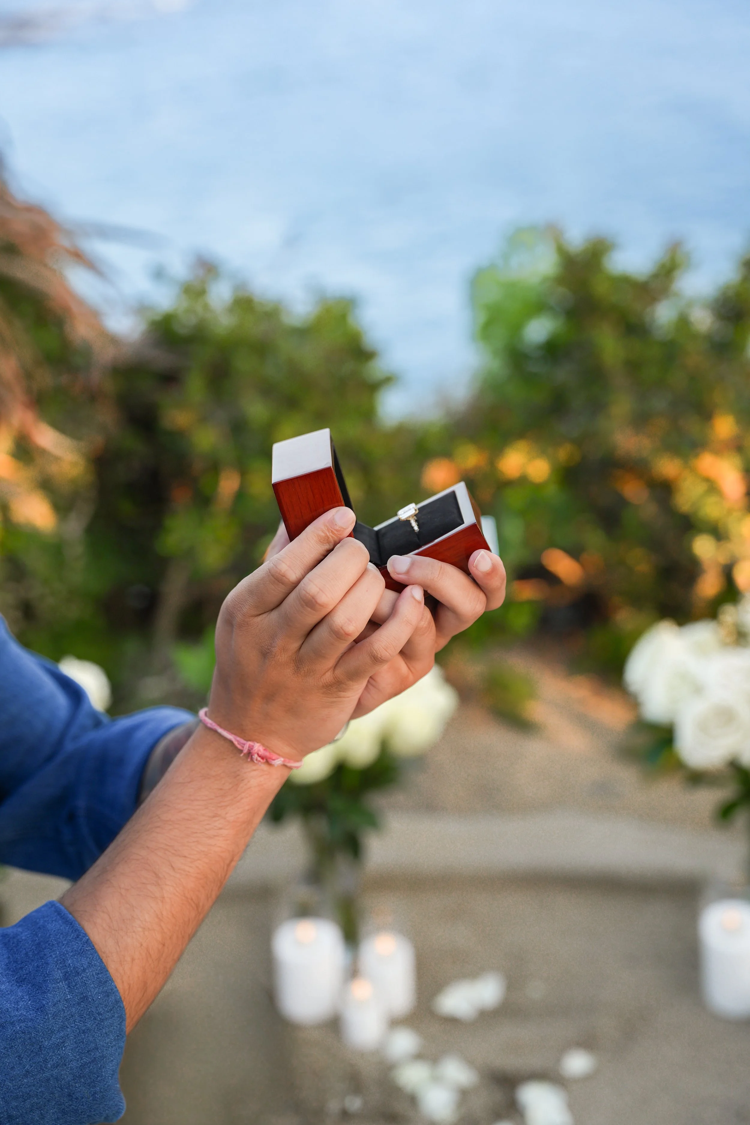 Close-up of proposal floral arrangements with roses and decorative greenery.