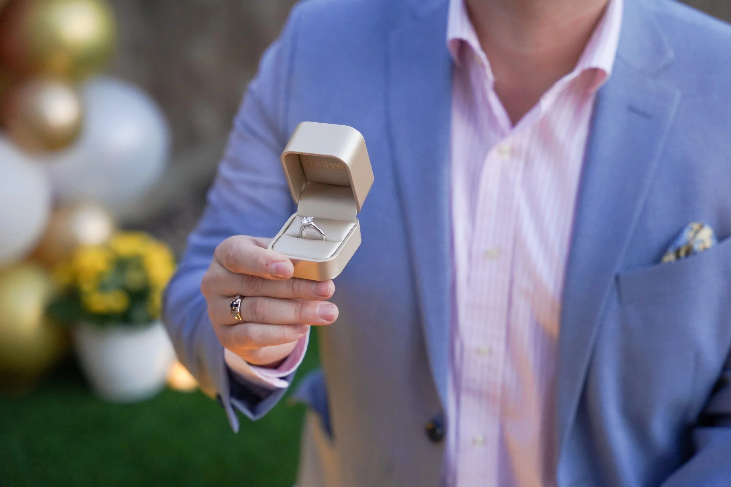 Close-up of the engagement ring during a San Diego at-home proposal, captured on a floral décor setup arranged by friends and family for this last-minute celebration.
